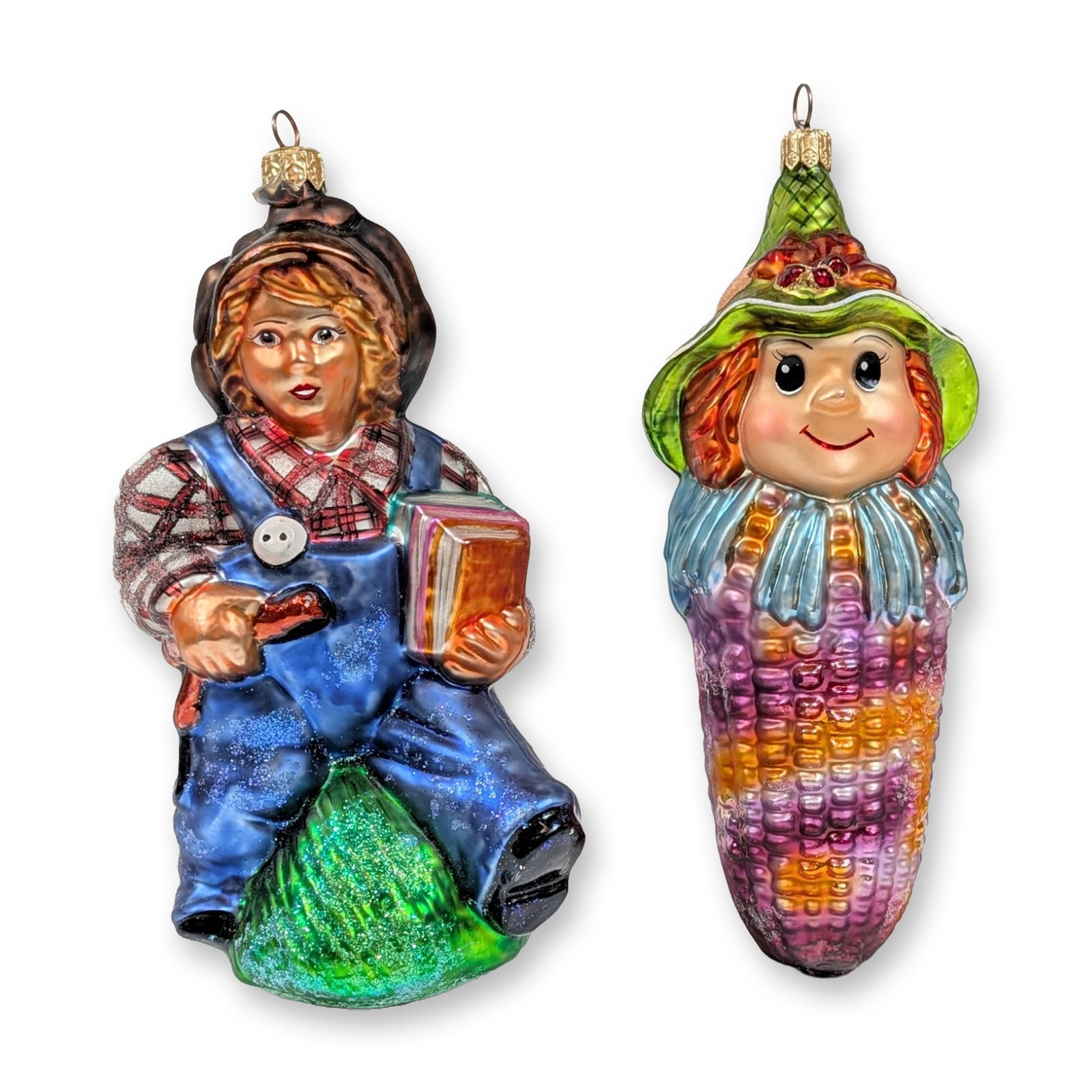 Two Christopher Radko Glass Harvest Ornaments: Christopher Radko. Pair of figural ornaments in hand-blown and hand-painted glass with glitter accents and silvered interiors. One ornament depicts a boy in blue overalls and a red plaid shirt seated 