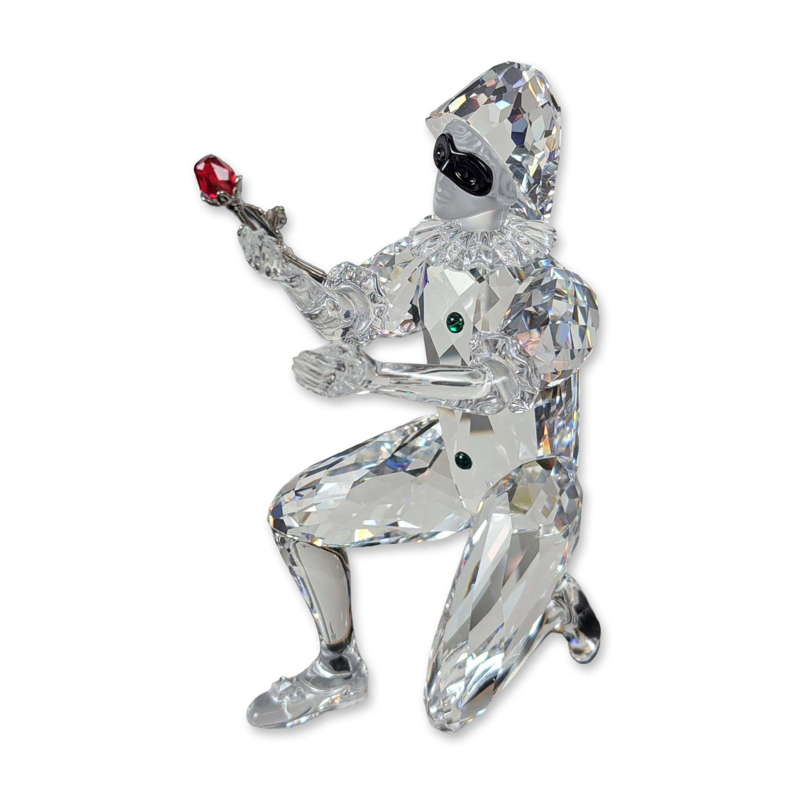 Swarovski 2001 SCS Annual Edition Crystal Figurine, Masquerade Harlequin, Pin and Base: SCS Annual Edition Masquerade Harlequin figurine in faceted and frosted lead crystal. The kneeling figure features a black crystal mask, green crystal buttons, and holds a red crystal rose on a metal 