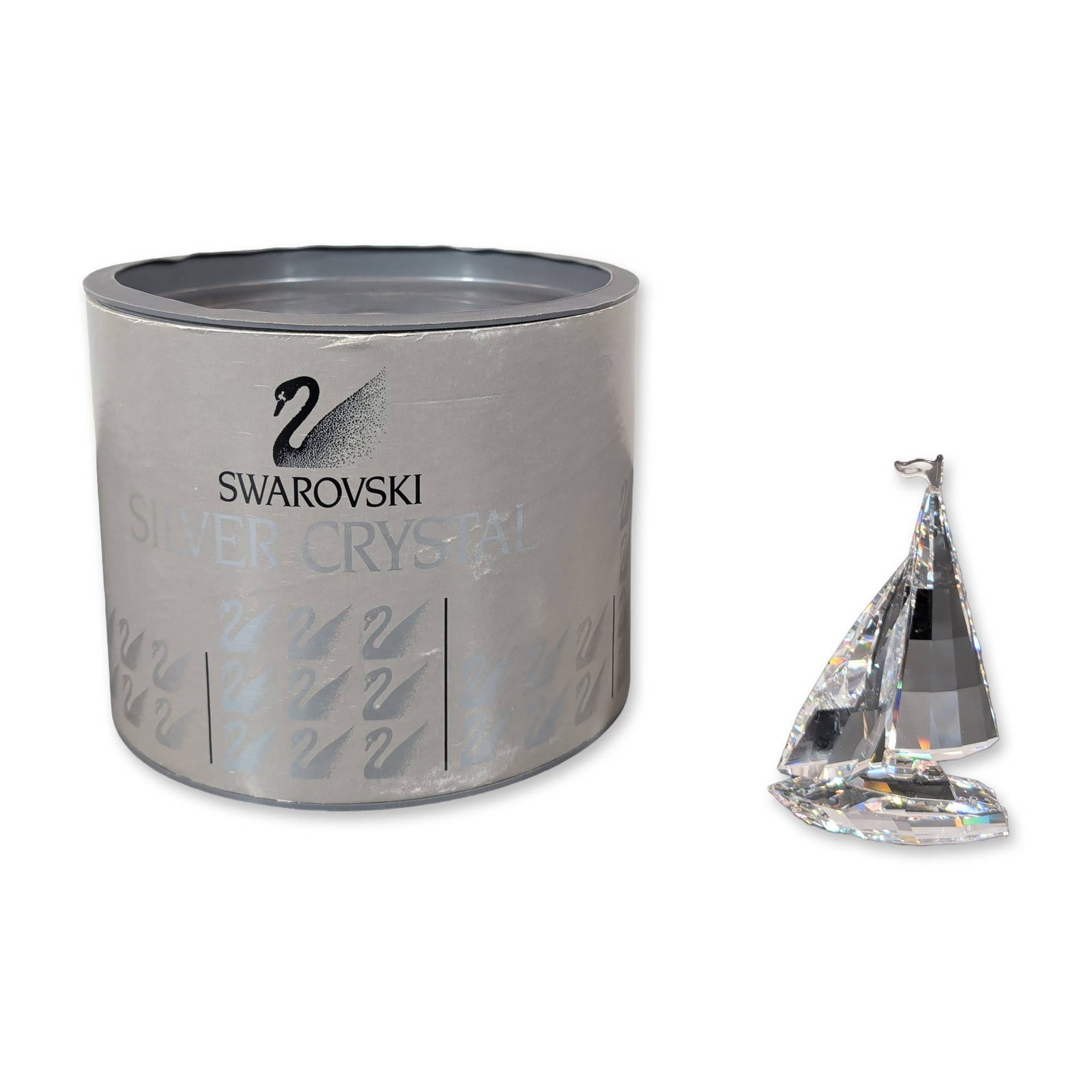 Swarovski Silver Crystal Sailboat: Swarovski Silver Crystal figurine in the form of a sailboat designed by Gabriele Stamey. The piece is constructed from faceted lead crystal with geometric sails and a hull, accented by a delicate meta