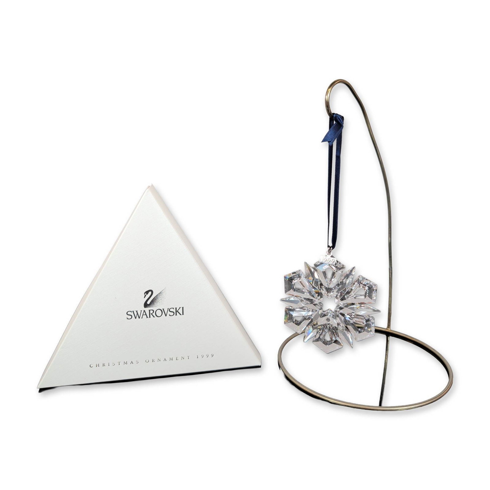 Swarovski 1999 Annual Edition Crystal Ornament: Swarovski. 1999 Annual Edition Christmas ornament in faceted lead crystal, designed as a six-pointed snowflake or starburst. The piece features alternating large and small points arranged around a cen