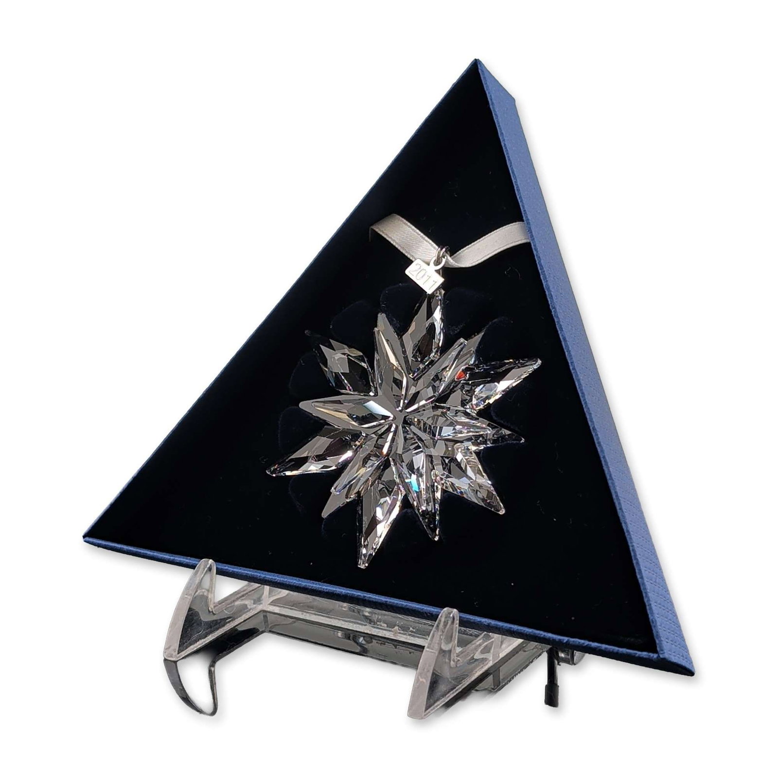 Swarovski 2011 Annual Edition Crystal Christmas Ornament: Swarovski 2011 Annual Edition Christmas ornament in faceted clear crystal, featuring a twelve-point star design. Suspended from a white satin ribbon with an attached metal date tag stamped 2011. The m