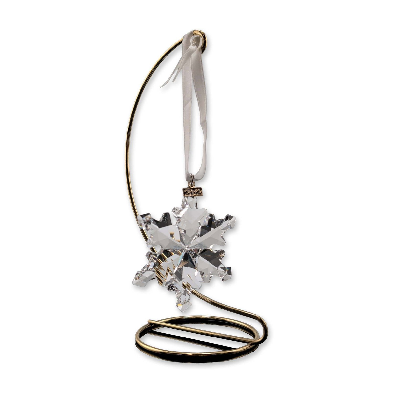 Swarovski 2012 Annual Edition Crystal Snowflake Ornament: Swarovski annual edition Christmas ornament for the year 2012. The piece is crafted from clear, highly faceted lead crystal in a multi-pointed snowflake design and suspended from a white satin ribbon.