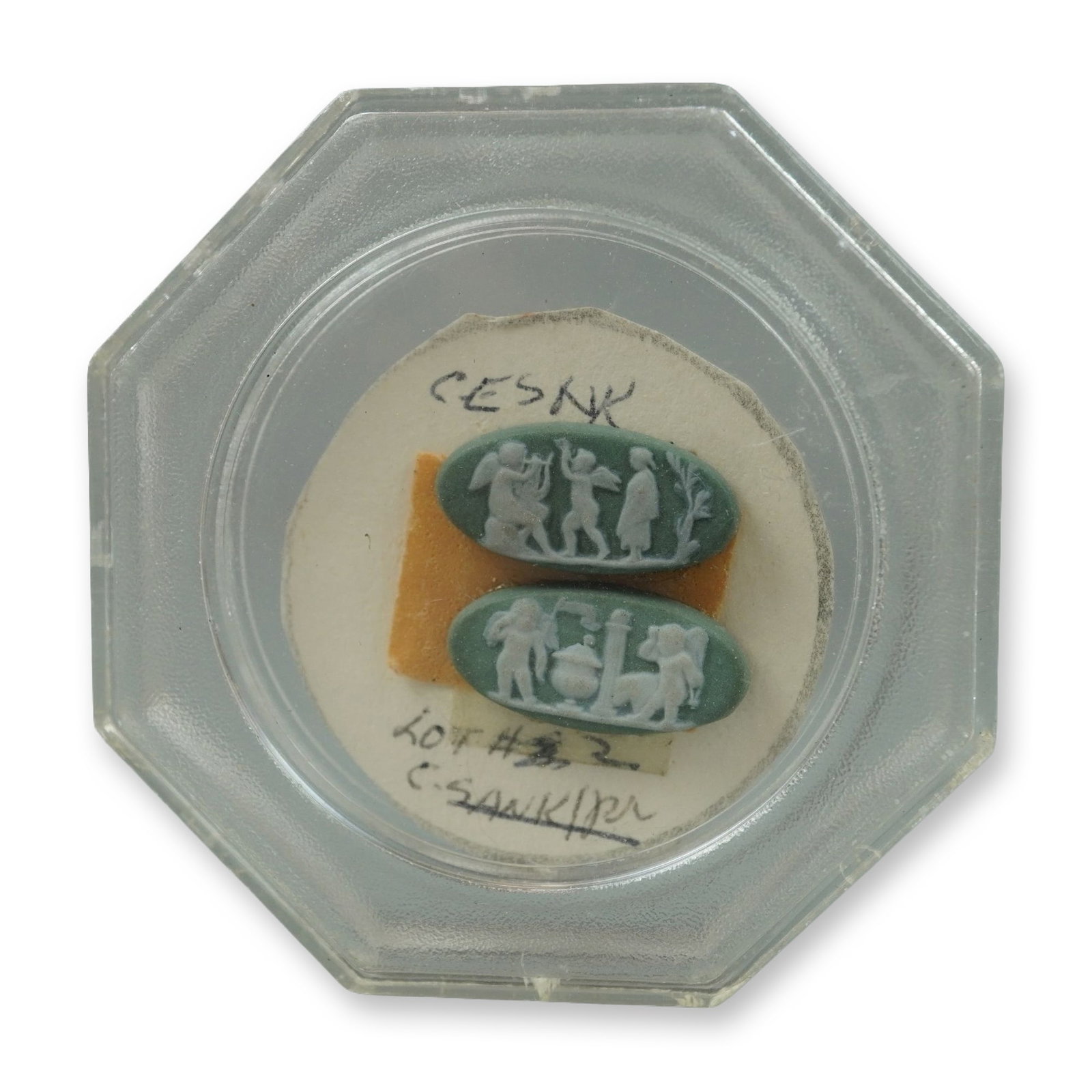 2pc Sage Green Jasperware Neoclassical Cameos: This pair of small oval cameos is crafted from sage green jasperware with applied white bas-relief decoration. The neoclassical motifs are consistent with the style popularized by Wedgwood. One cameo 