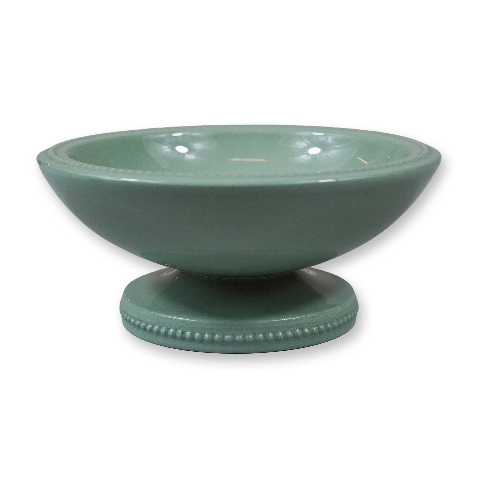 Wedgwood Norman Wilson Glazed Earthenware Pedestal Bowl with Bull Motif: A pedestal bowl manufactured by the British firm Wedgwood, featuring a celadon glaze. The circular bowl is supported by a flaring foot, with both the rim and the base of the foot decorated with molded