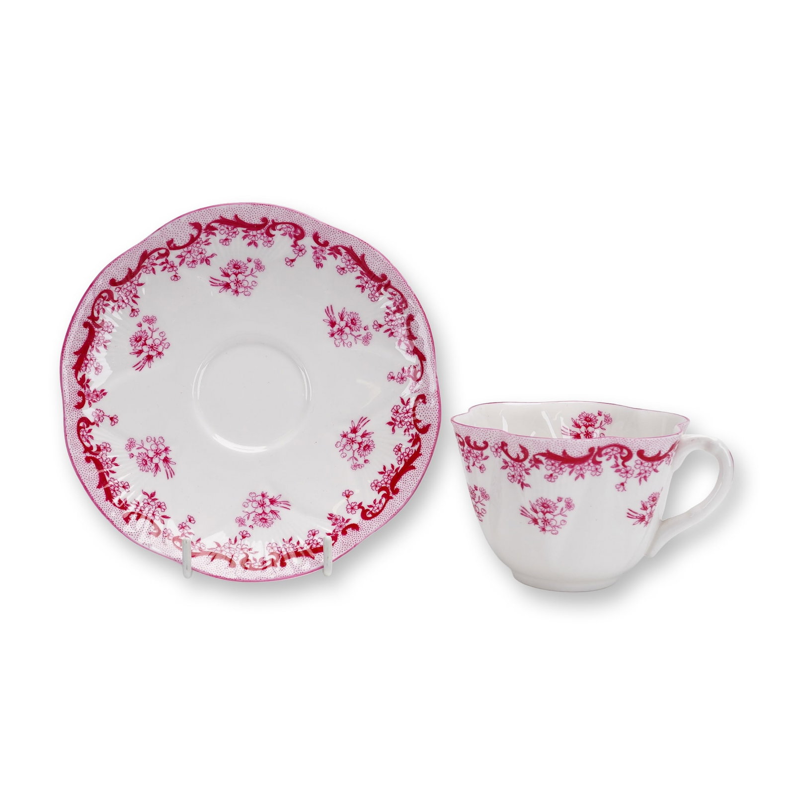 Shelley England Dainty Pink Floral Cup and Saucer Set: A two-piece fine bone china teacup and saucer set manufactured by Shelley in England. The set features the iconic Dainty shape, characterized by a fluted, lobed body and scalloped, wavy rims. The