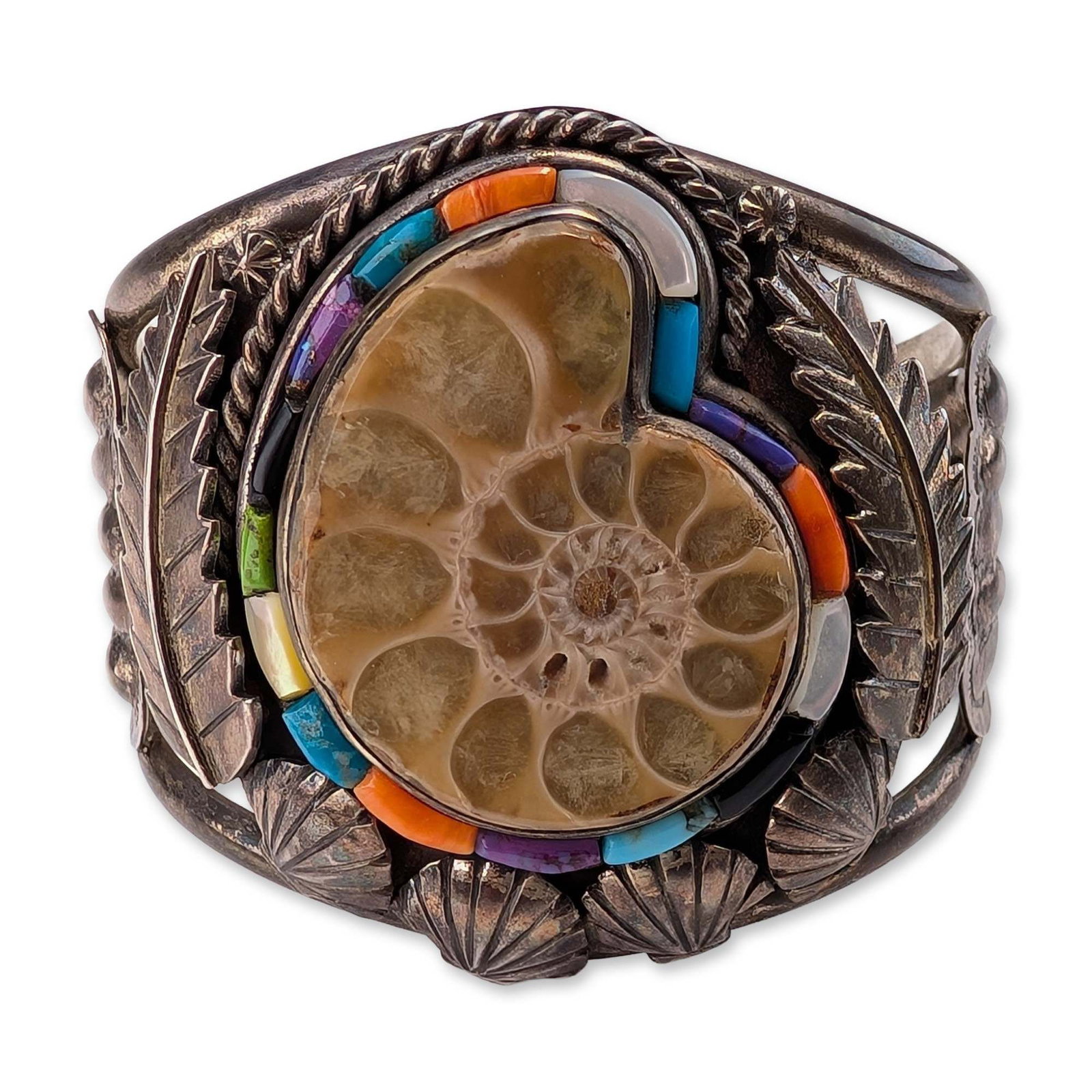 Freddy Maloney Navajo Sterling Silver Ammonite Cuff Bracelet: Freddy Maloney (Navajo), contemporary Southwestern cuff bracelet in sterling silver. The central setting features a polished ammonite fossil section bordered by multi-stone mosaic inlay including turq