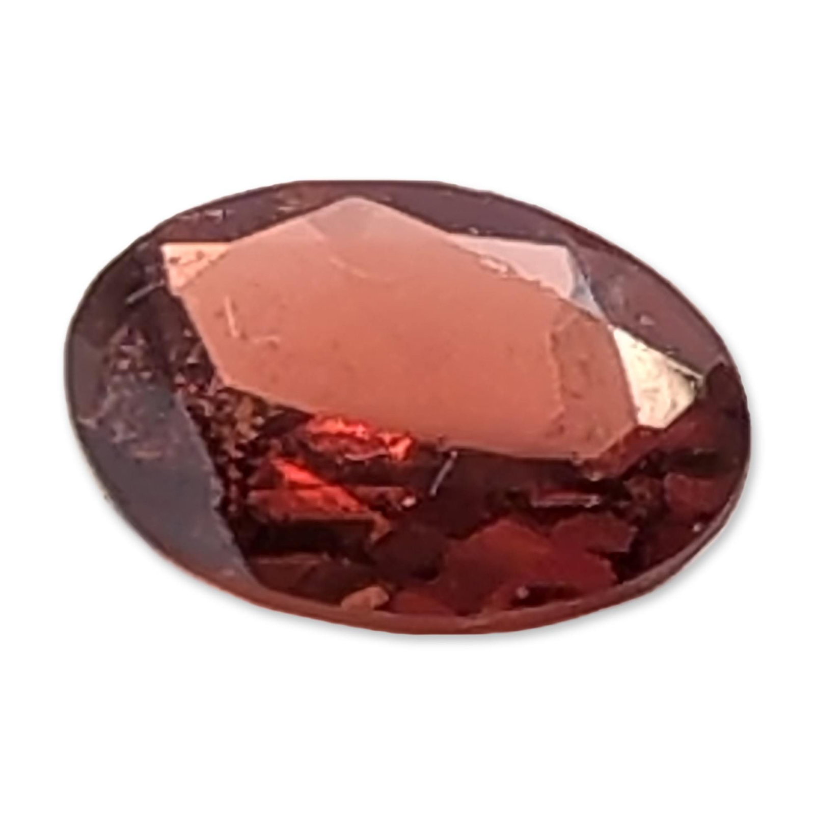 Loose Oval Faceted Reddish-Brown Gemstone: A loose faceted gemstone, oval cut, featuring a saturated, deep reddish-brown color with brownish-orange undertones. The stone exhibits visual characteristics that appear to be consistent with the