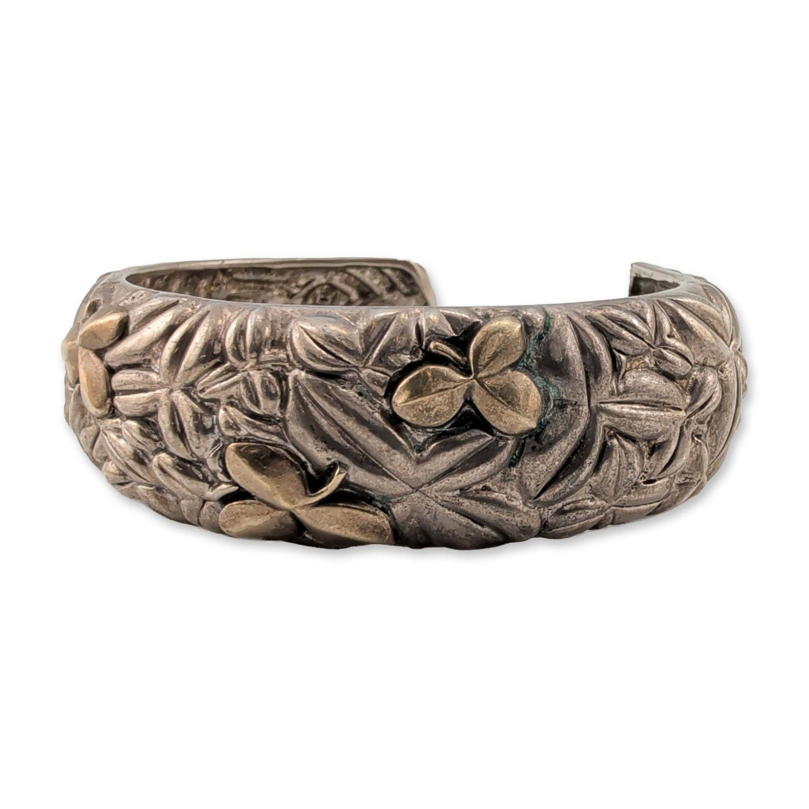 Bill Blass Two-Tone Sterling Silver and 18K Gold Cuff Bracelet: Bill Blass botanical cuff bracelet in sterling silver with gold accents. This open-ended cuff features a high-relief design of stylized foliage and three-leaf clovers. The piece is constructed with a