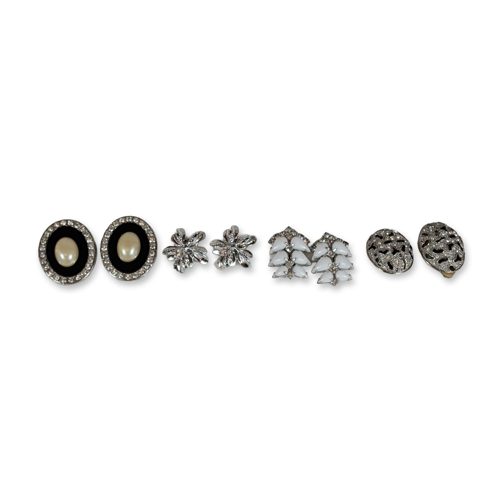 Group of Four Pairs Vintage Costume Earrings: Collection of vintage silver-tone costume clip-on earrings. Features one pair of Kramer leaf-motif earrings set with white navette-shaped opaque cabochons; one pair of oval-form earrings with clear rh