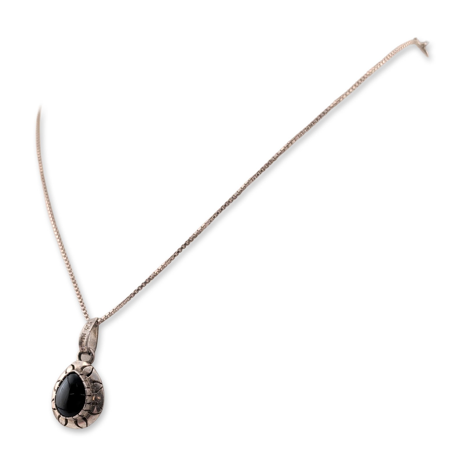 Mexican Sterling Silver Black Onyx Pendant Necklace: Mexican artisan style pendant necklace in 925 sterling silver. The pendant features an oval black onyx cabochon secured in a bezel setting, surrounded by an ornamental frame with repeating recessed pe