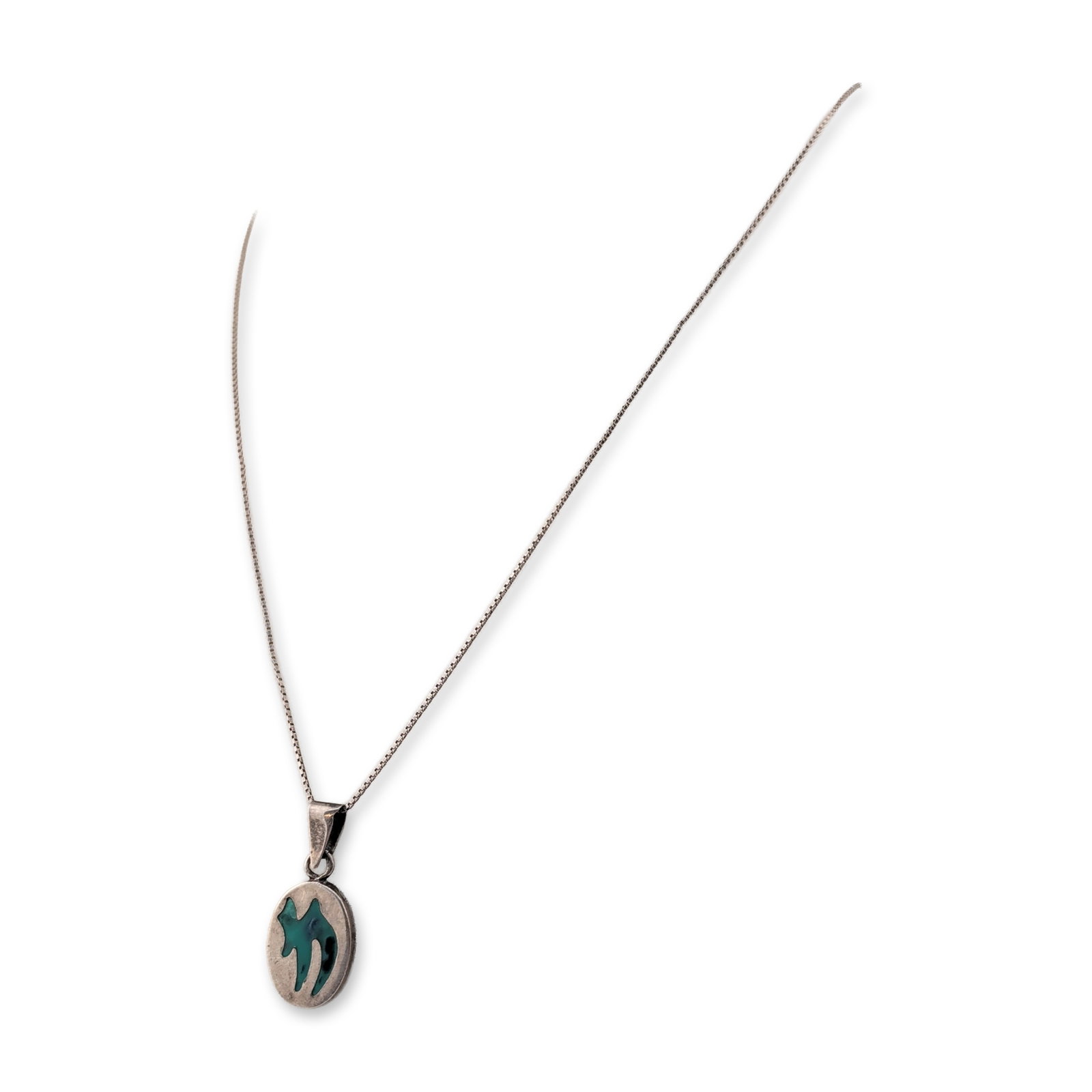 Sterling Silver Reversible Enamel Pendant Necklace: Sterling silver pendant necklace featuring a reversible oval pendant. One side is decorated with a stylized green inlay depicting a figure in motion, resembling a bird in flight. The reverse side feat