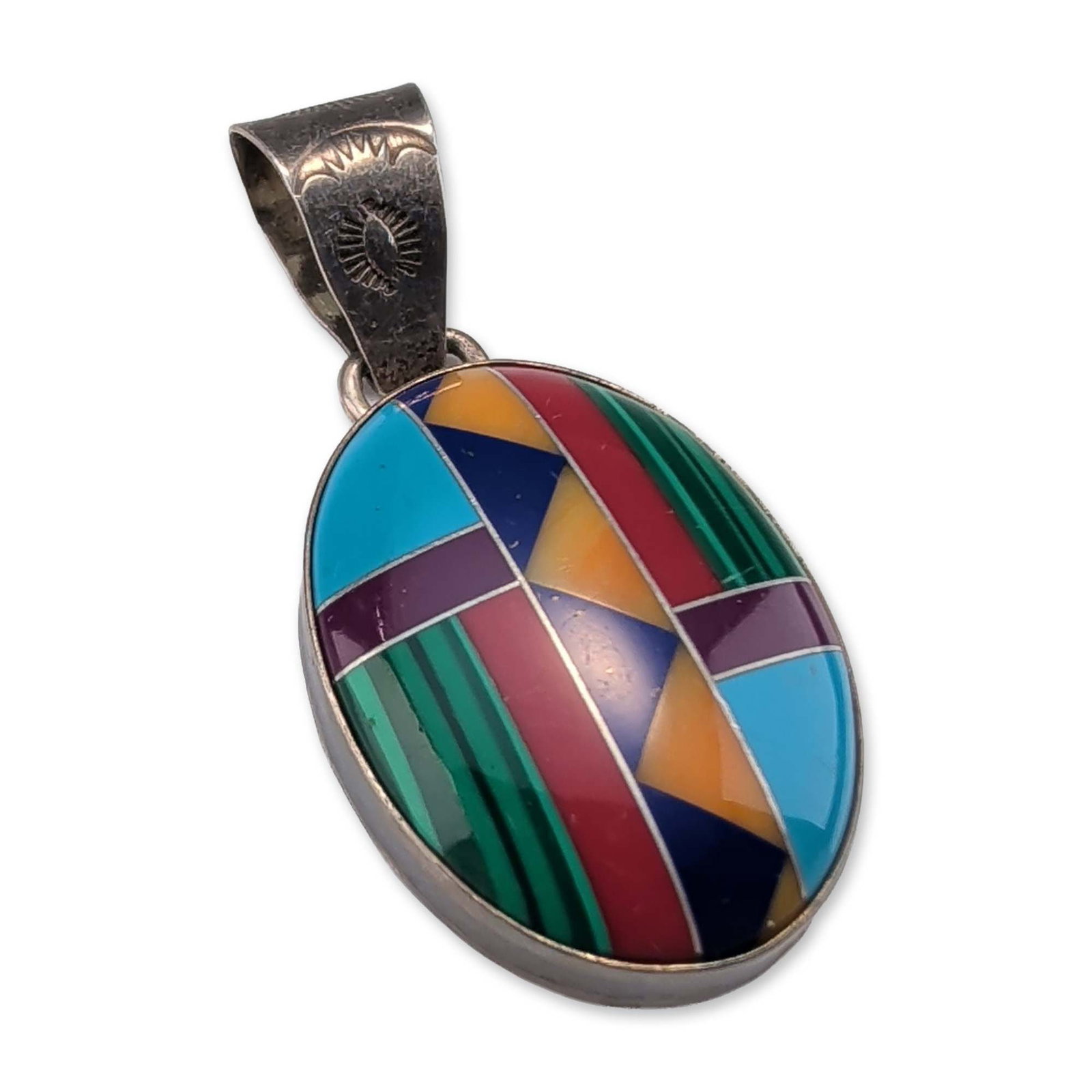 Southwestern Sterling Silver Multi-Stone Inlay Pendant: Southwestern pendant in sterling silver, featuring a multi-stone geometric intarsia inlay including malachite, turquoise, lapis lazuli, sugilite, and spiny oyster shell. The oval form is suspended fro