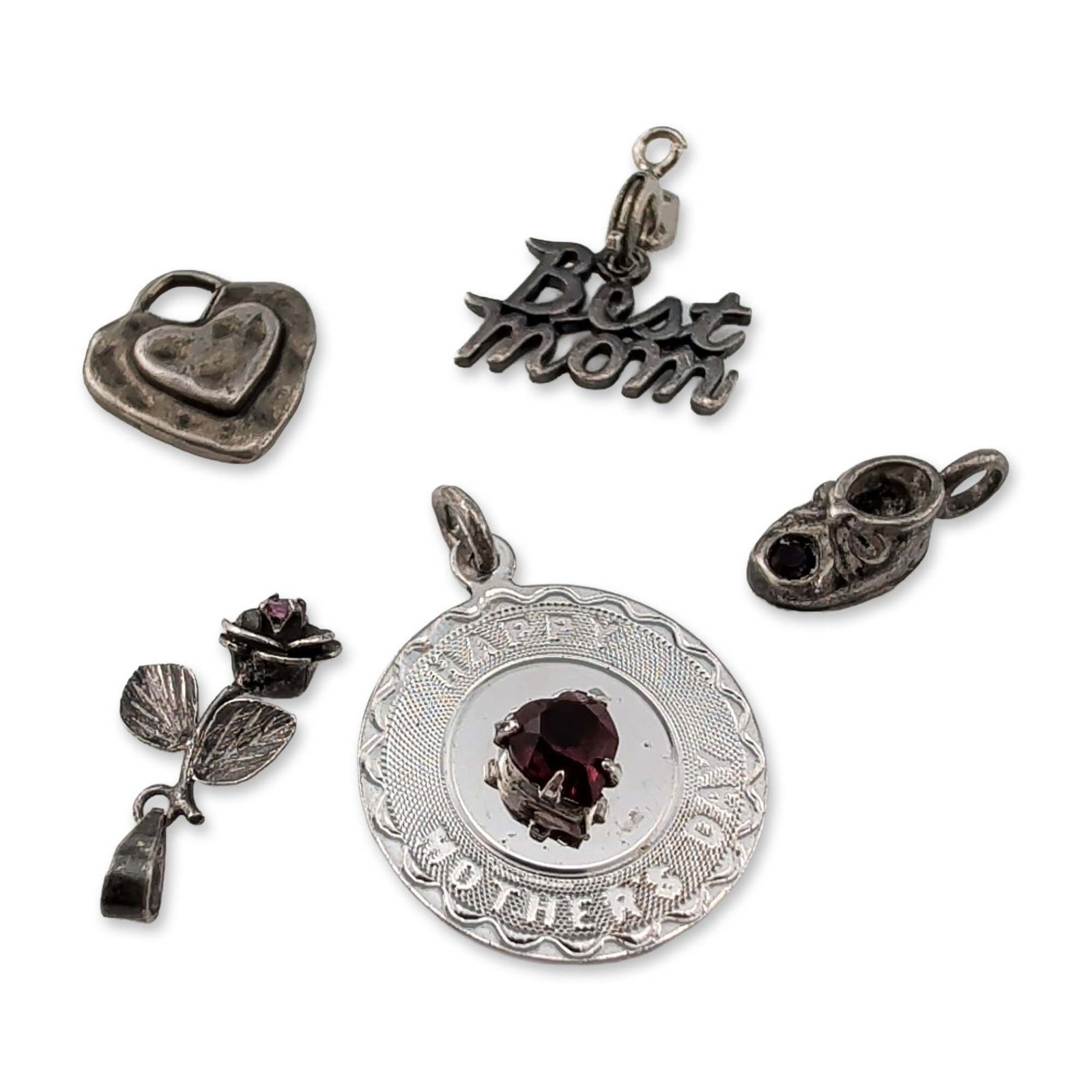 Collection of Sterling Silver Pendants: Collection of five sterling silver pendants and charms with sentimental and figural themes. The lot includes a circular medallion inscribed Happy Mother's Day with a central heart-shaped red faceted