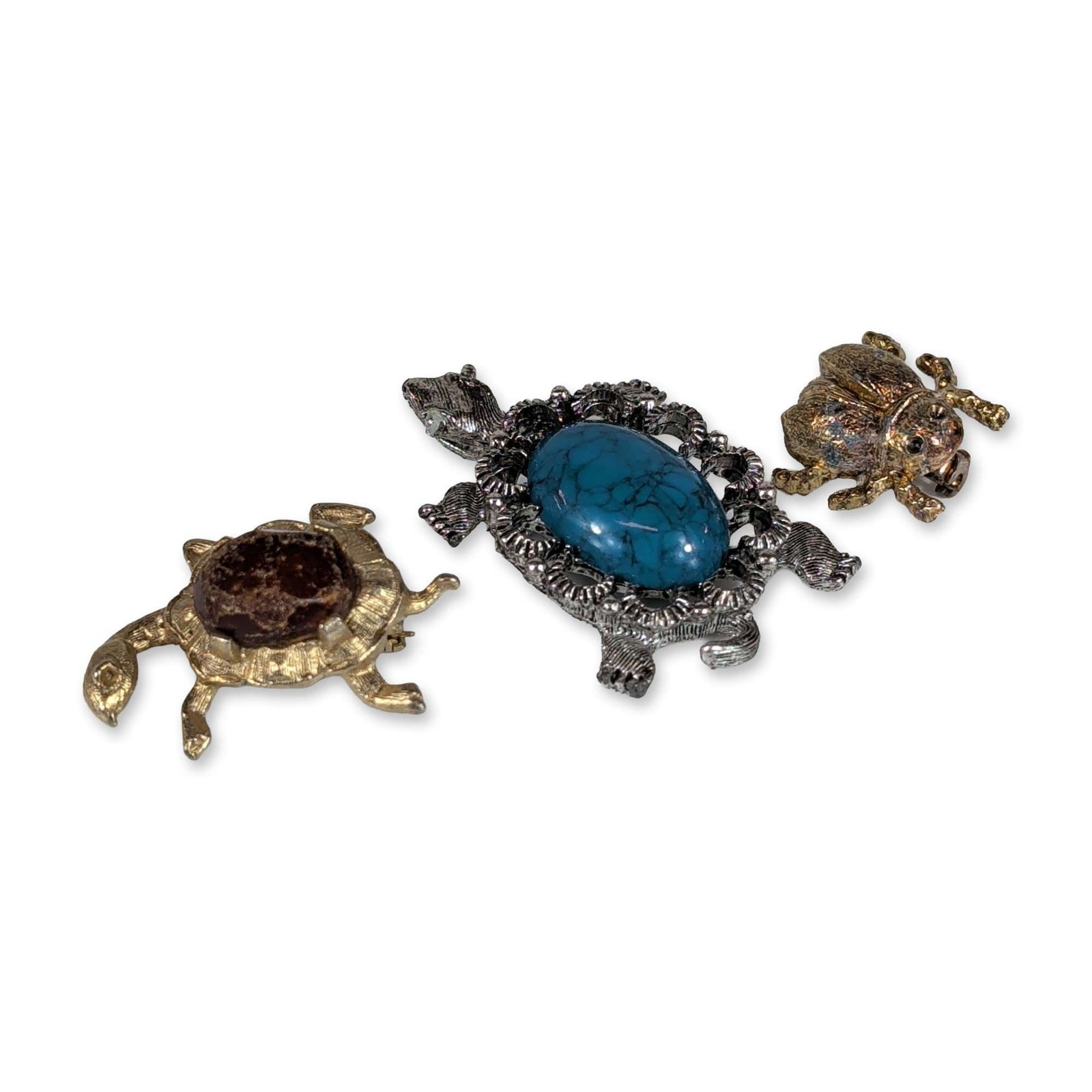 Trio of Turtle and Beetle Brooches: Trio of animal-themed costume jewelry brooches featuring turtle and insect motifs. Included is a silver-tone turtle brooch set with a large oval turquoise-colored cabochon with matrix, bordered by