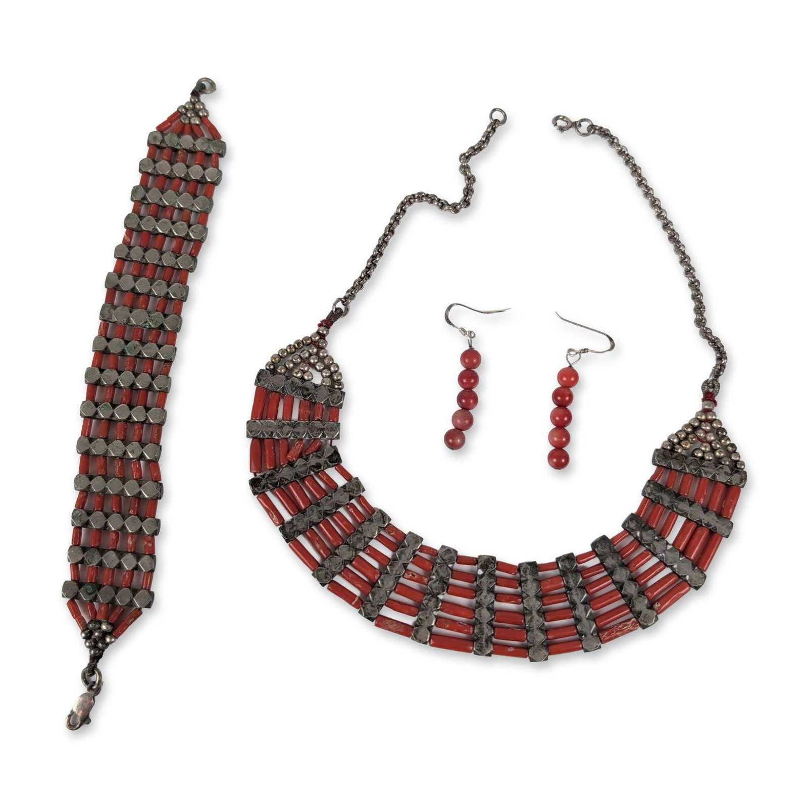 4pc Indian Style Red Coral and Metal Jewelry: Indian style. Collection of jewelry comprising a necklace, wide bracelet, and pair of earrings. Constructed with red tubular and spherical beads appearing to be coral, accented by metal components wit