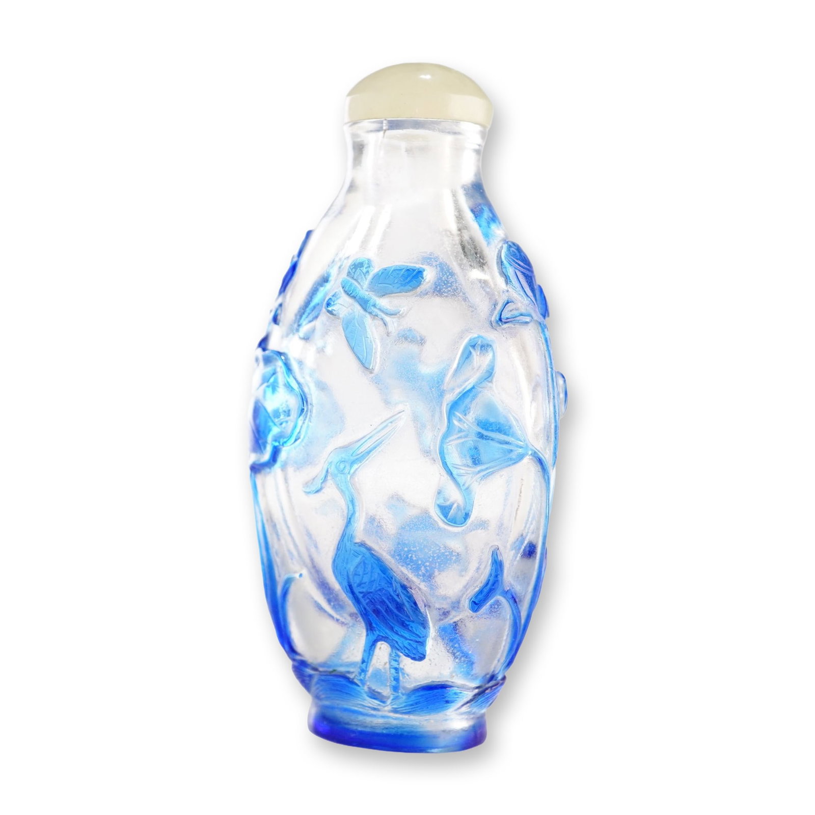 Peking Glass Snuff Bottle, Blue Overlay Lotus and Crane: Featuring a blue relief overlay on a clear Peking glass snuff bottle, this piece is decorated with lotus flowers, leaves, and pods, cranes, and a butterfly. It is presented with a light sage green sto