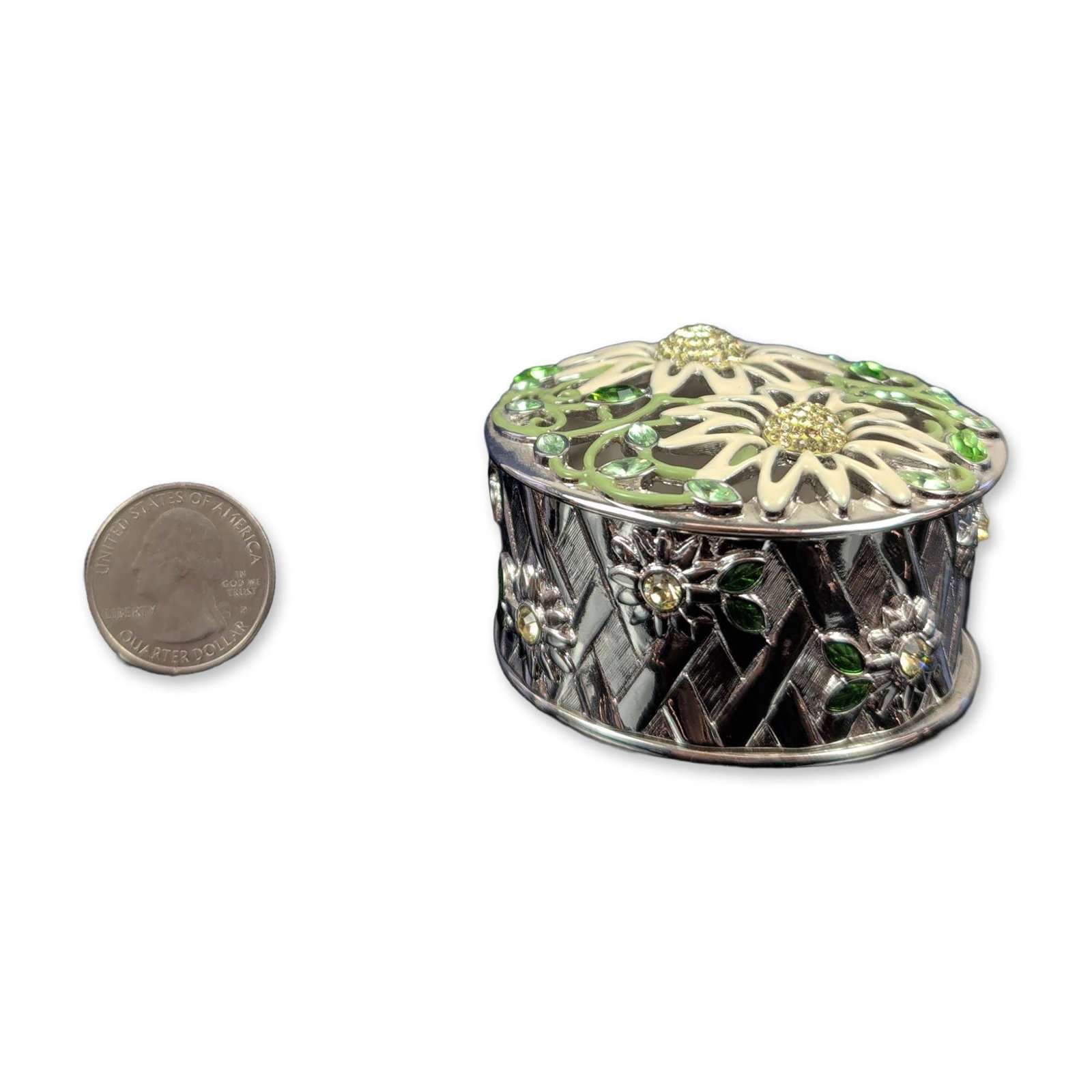 Swarovski Crystal Mothers' Day Daisy Jewel Box: Swarovski jewelry box in silver-toned metal, featuring a pierced lid decorated with white enameled daisies, yellow crystal centers, and green crystal-accented vines. The circular body exhibits a baske