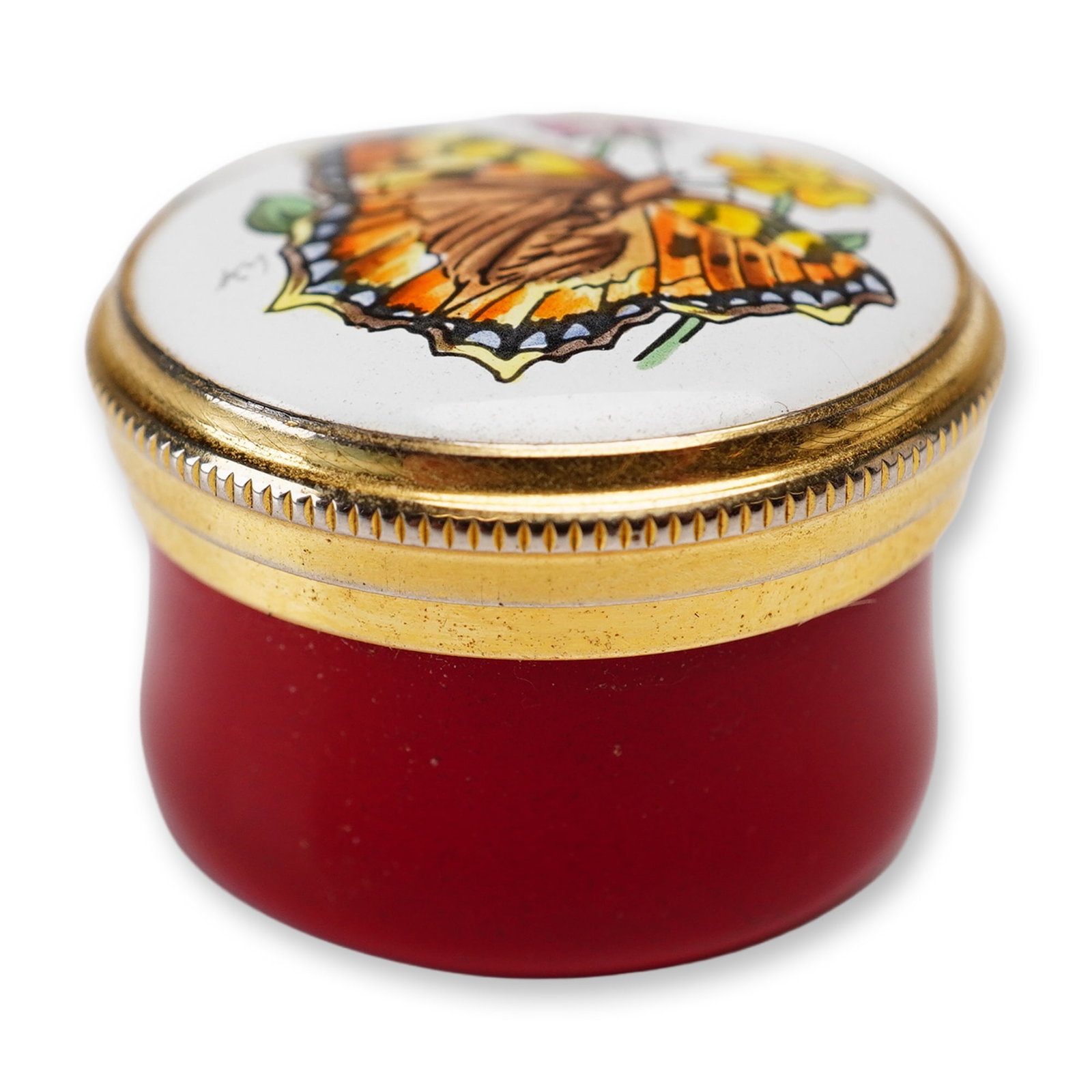 Crummles English Enamel Treasure Box Butterfly with Flowers: The circular box is constructed of enamel on copper with gold-toned metal mounts. The domed lid displays a polychrome butterfly among yellow and purple wildflowers against a white background, while th