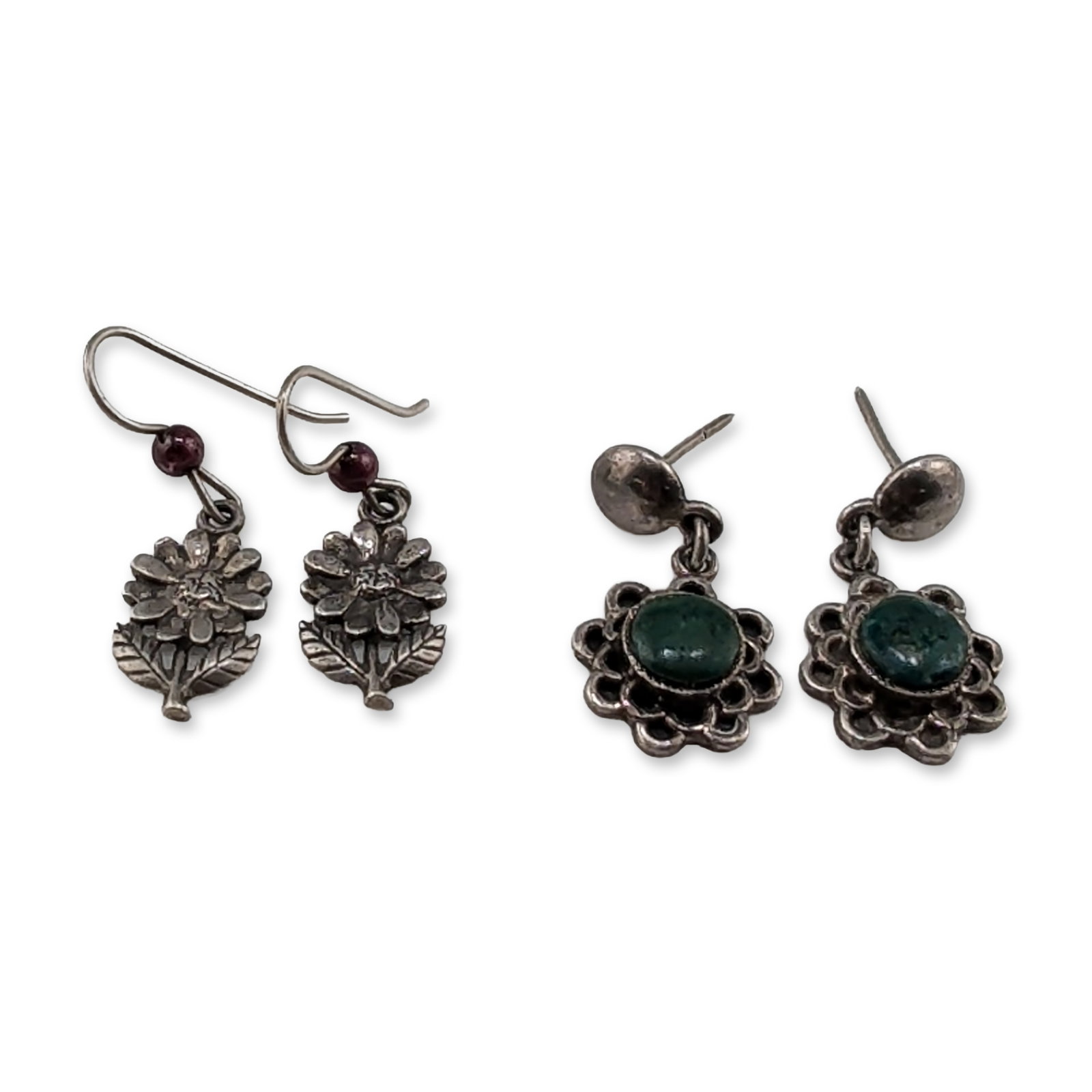 Two Pairs of Vintage Sterling Silver and 950 Silver Dangle Earrings: Group of two pairs of vintage silver drop earrings. The first pair features oval green cabochon stones set within scalloped floral borders and finished with post-style backings. The reverse of each ea