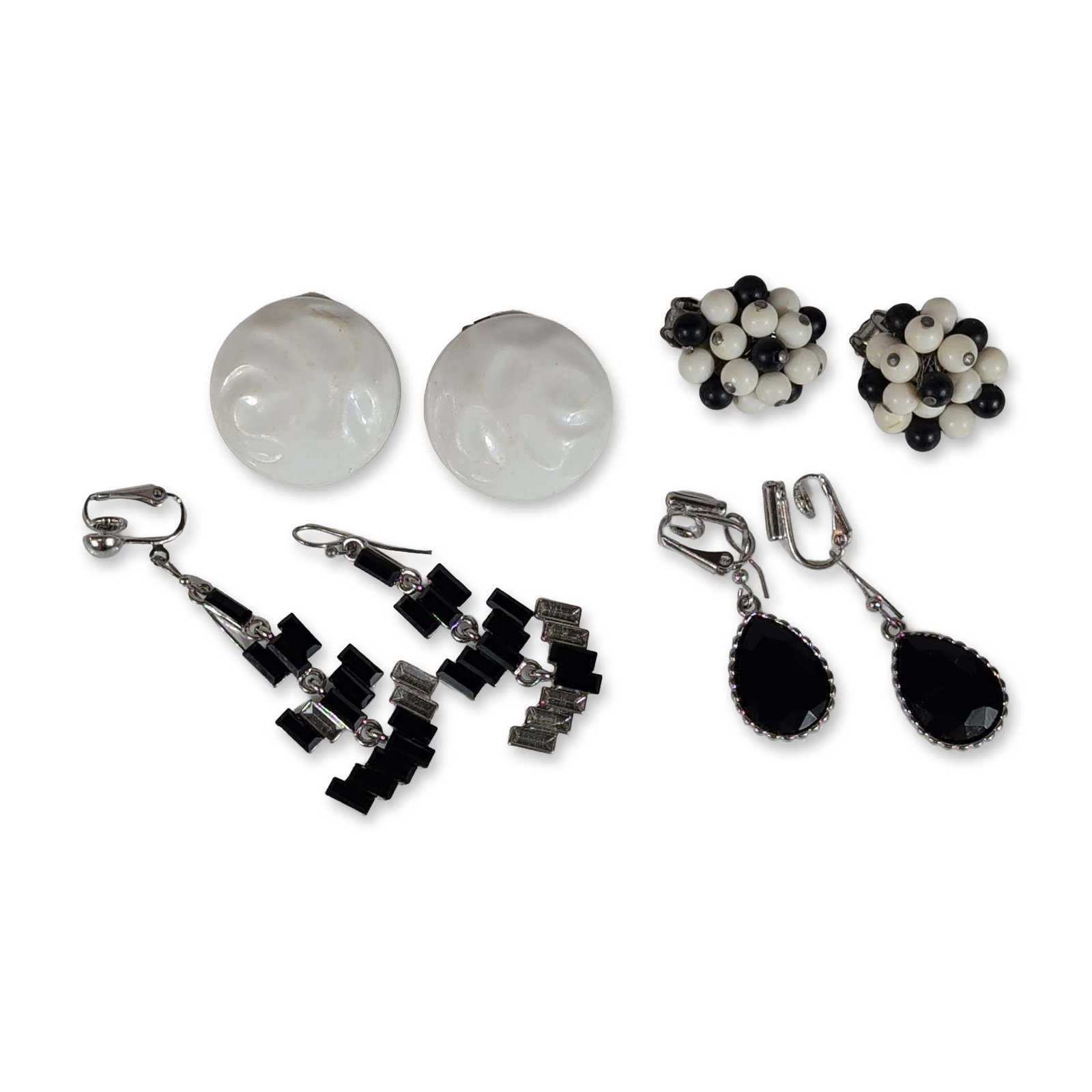 4 pair Collection of Vintage Black and White Earrings: Collection of vintage costume earrings in varied black and white designs. The group includes a pair of cluster earrings featuring small black and white round beads in silver-tone metal settings, marke