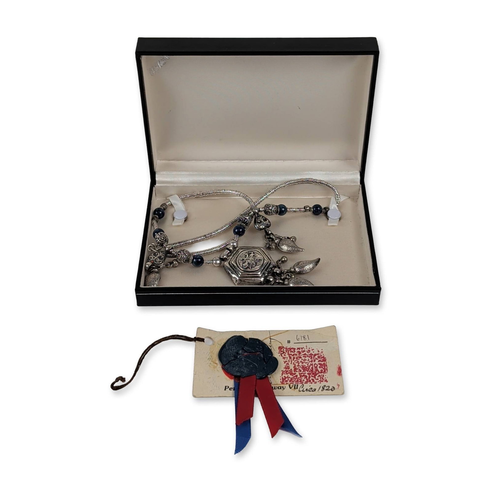 Tekke Turkmen Gilded Silver and Lapis Lazuli Tribal Necklace: Central Asian Tekke Turkmen tribal amulet necklace in predominantly 800 silver. The piece features a central hexagonal tawiz pendant with a relief circular medallion depicting a winged mythical figure