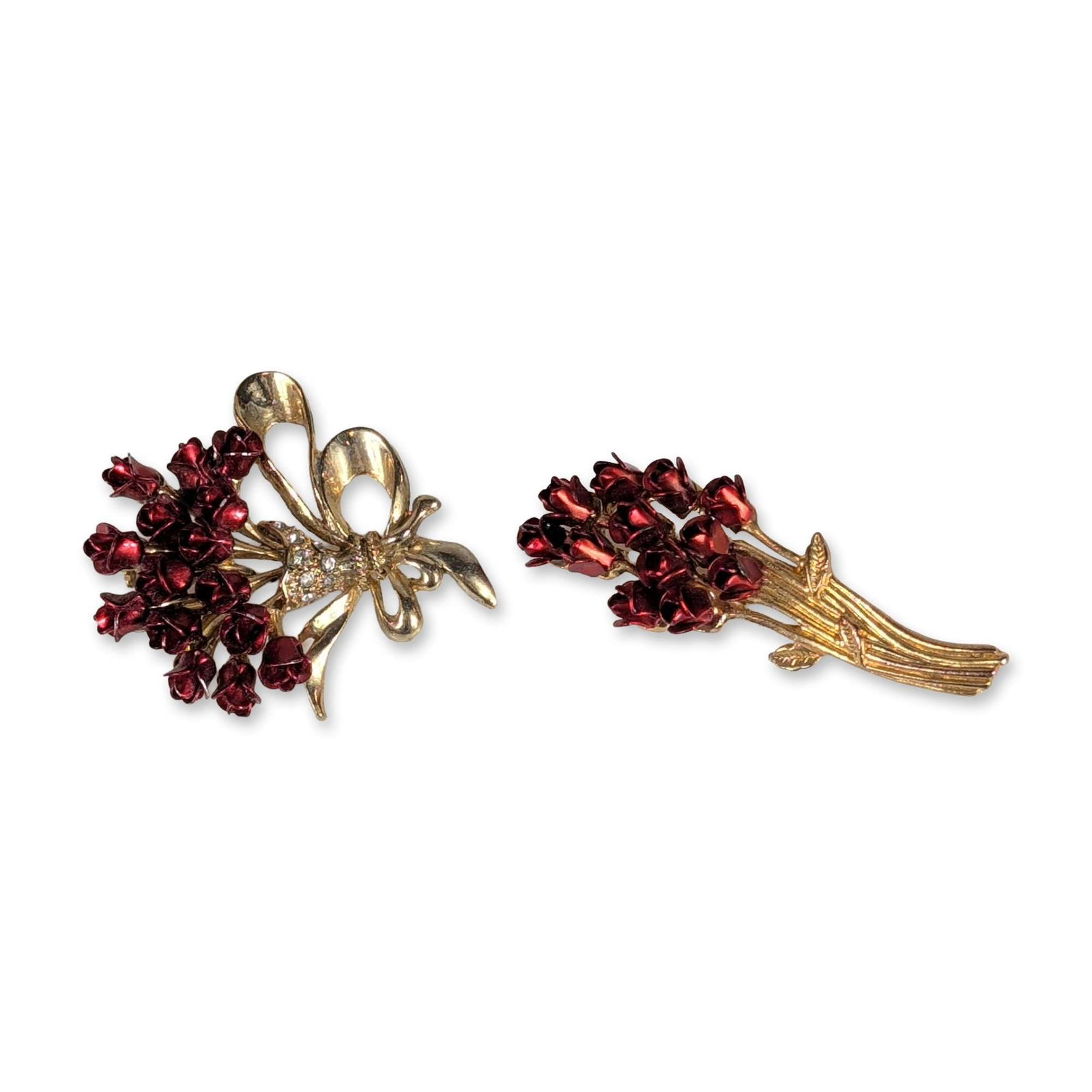 Pair of Vintage Floral Costume Brooches: Mid-20th century style floral costume brooches in gold-tone base metal and red enamel. Pair of pins featuring rosebud motifs, with one designed as a vertical spray with small leaves and the other as a