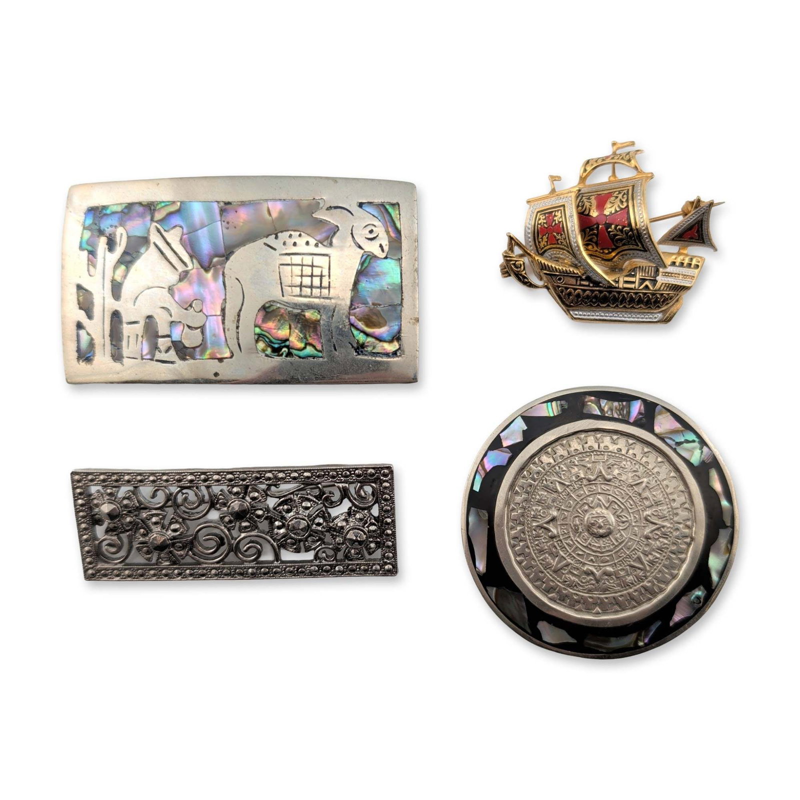 4pc Collection of Mexican and Spanish Brooches and Belt Buckle: Assortment of four pieces of vintage jewelry and metalwork. The lot includes a Spanish damascene-style figural brooch of a galleon in gold-tone metal with black and red inlay. Also featured is a circu