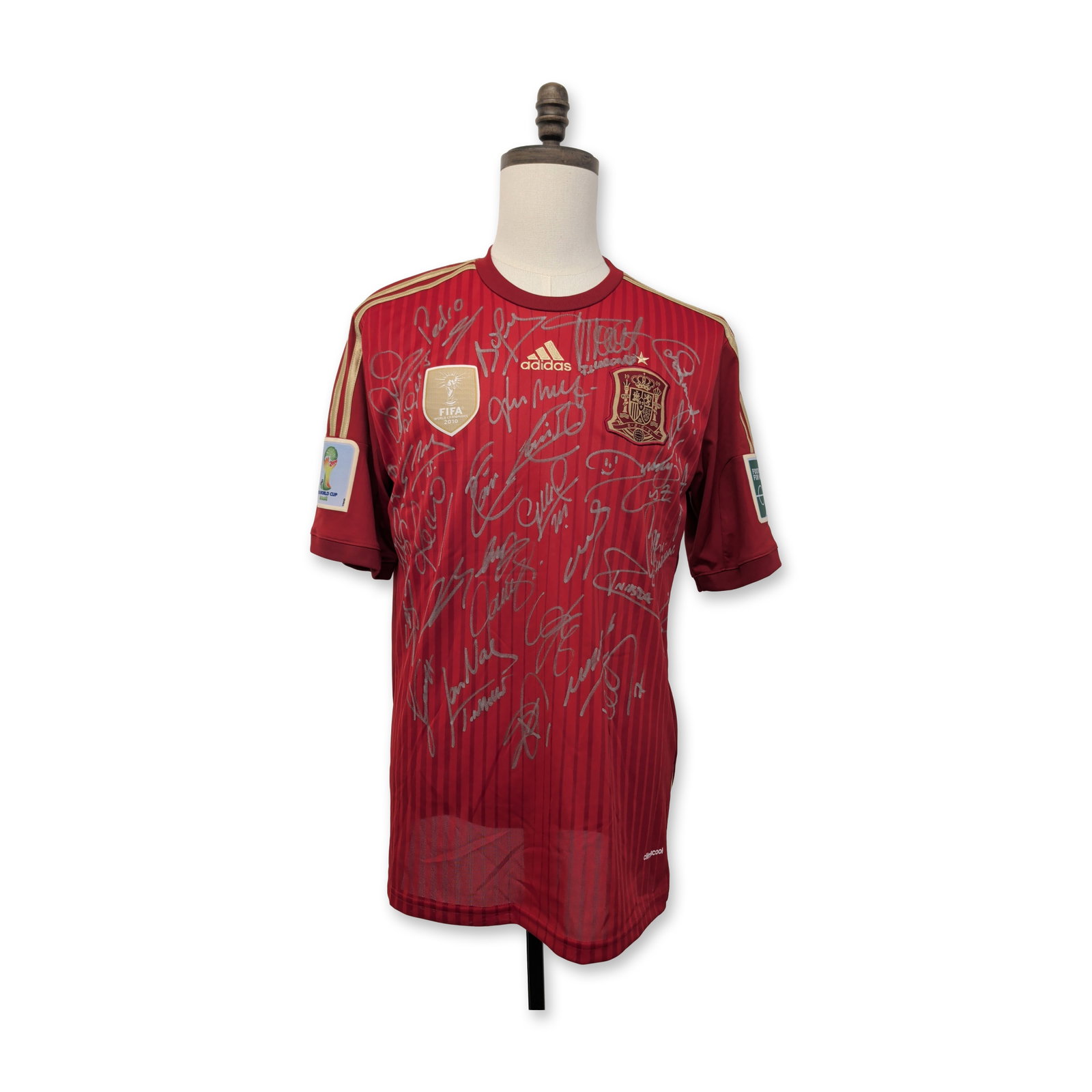 Team Signed Spain 2014 World Cup Soccer Jersey: Spain, 2014. Adidas Climacool home jersey in red fabric with tonal horizontal stripes and gold trim, featuring an embroidered national crest with championship star and center chest gold FIFA World Cha