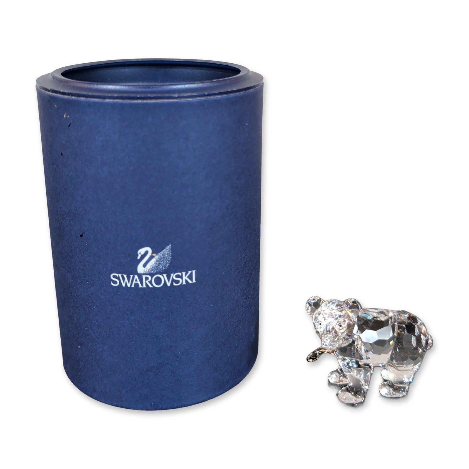 Swarovski Crystal Grizzly Cub Figurine: Grizzly Cub figurine in clear faceted lead crystal, featuring a walking bear form with multi-faceted body, black eyes and a silver tone metal fish in its mouth. The base is marked with the laser-etche