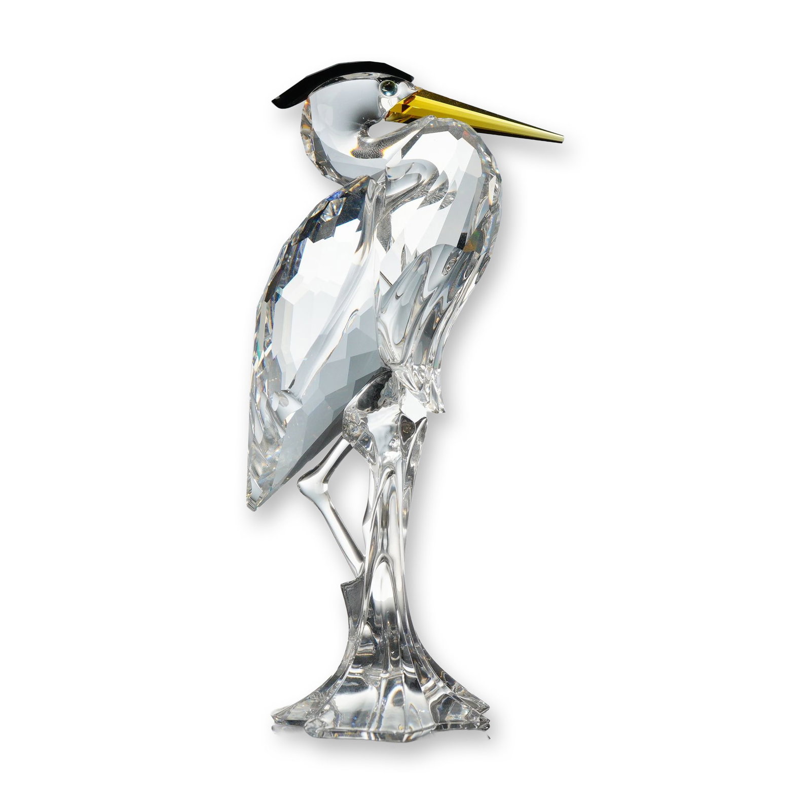 Swarovski Crystal Figurine, Silver Heron: Swarovski faceted lead crystal figurine depicting a Silver Heron, designed with a clear crystal body, a black crystal crest, and a golden-yellow crystal beak. The bird is depicted standing on a clear 