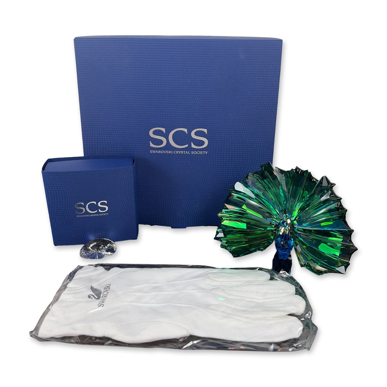 Swarovski SCS 2015 Annual Edition Peacock Arya and Crystal Title Plaque: Swarovski crystal piece designed by Martin Zendron of a Peacock, titled Arya, in faceted lead crystal, featuring a deep blue body and iridescent green and blue Aurora Borealis finish tail feathers. In