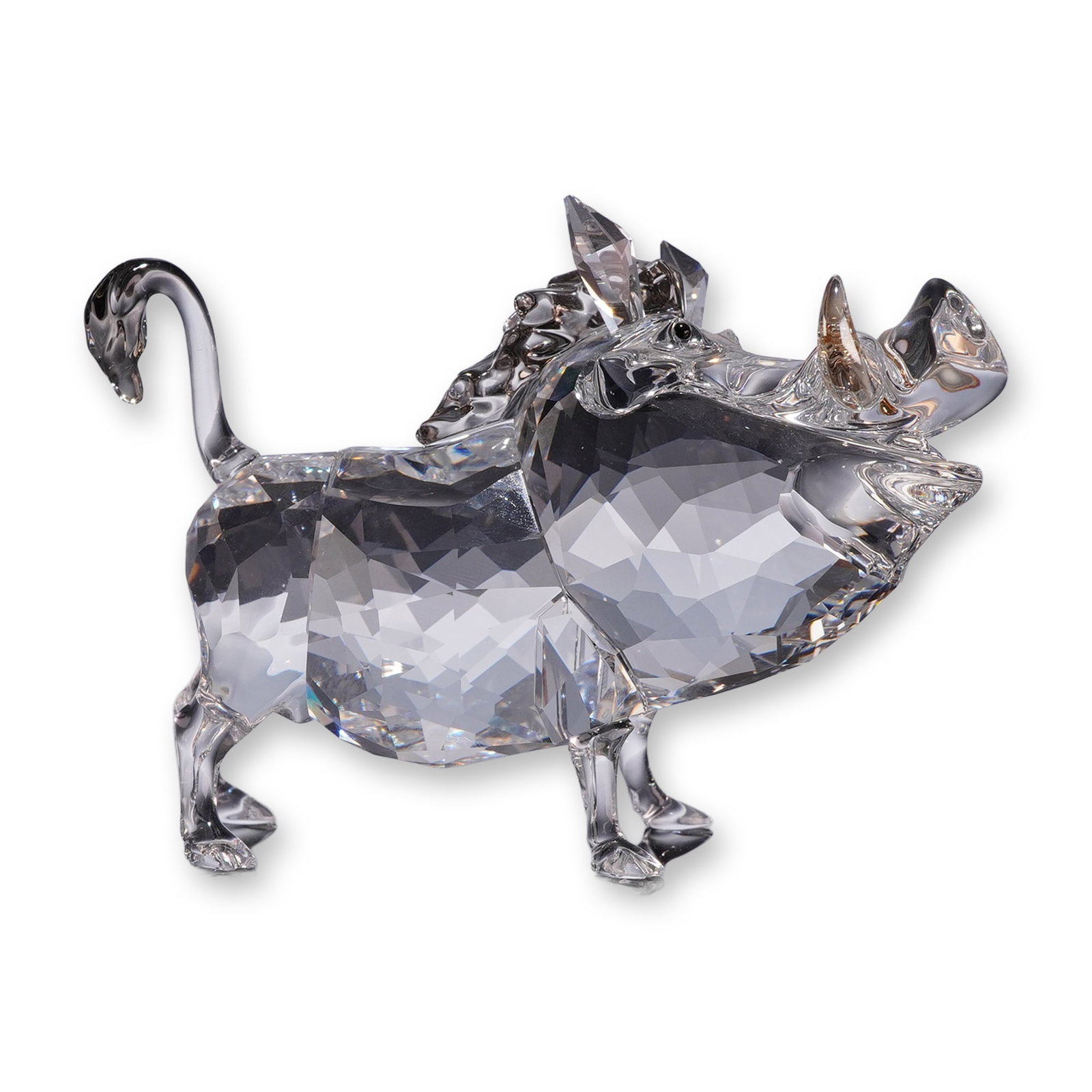 Swarovski Crystal Disney Warthog Figurine, Lion King Pumbaa: Swarovski Disney collection faceted clear crystal figurine depicting the character Pumbaa the warthog from The Lion King, The figure is constructed with a faceted crystal body, featuring golden-amber 