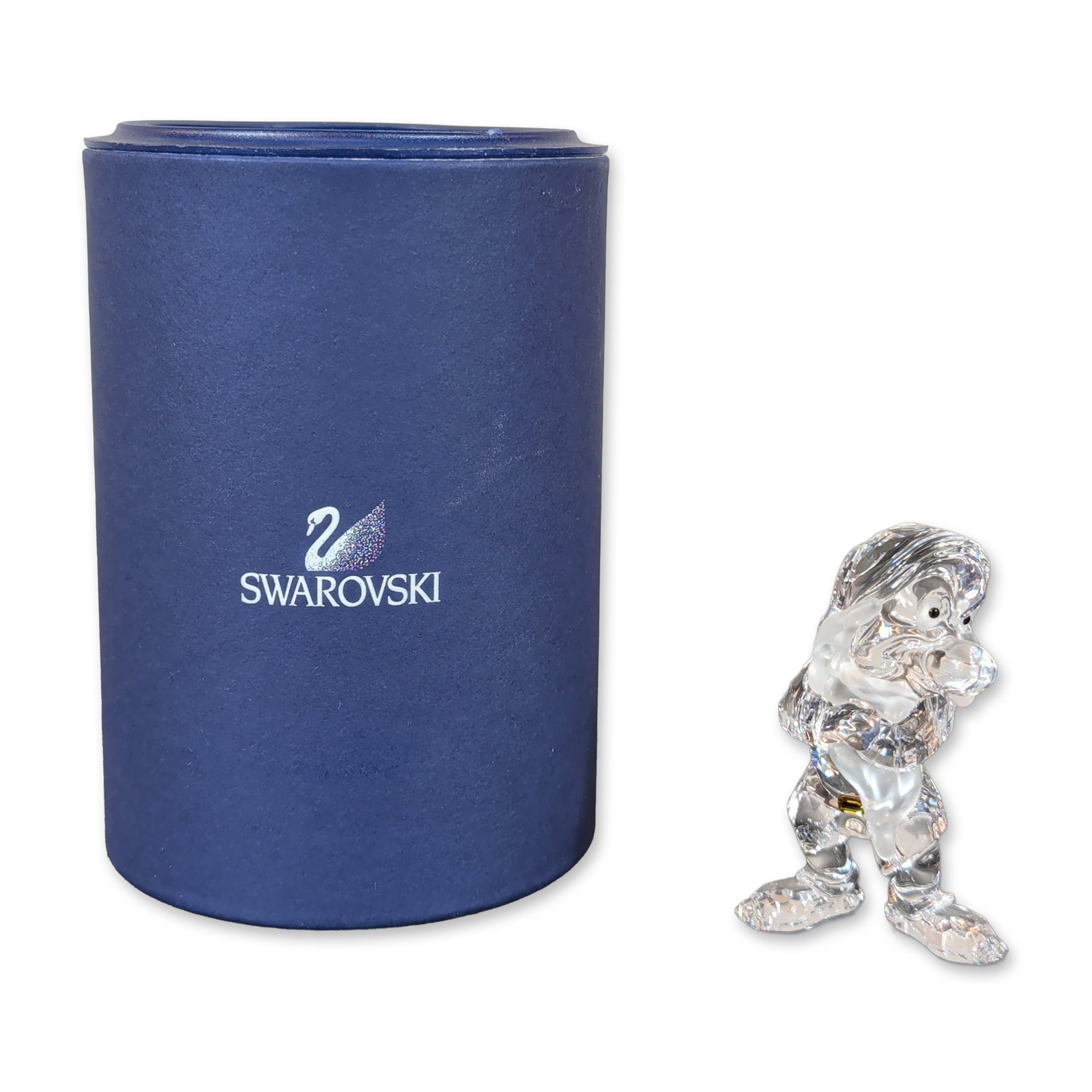 Swarovski Crystal Disney Snow White Grumpy Figurine: Grumpy figurine crafted in faceted clear lead crystal with frosted crystal accents to the face, and hands. The character is depicted with dark crystal eyes. Laser-etched Swarovski swan logo on the bas