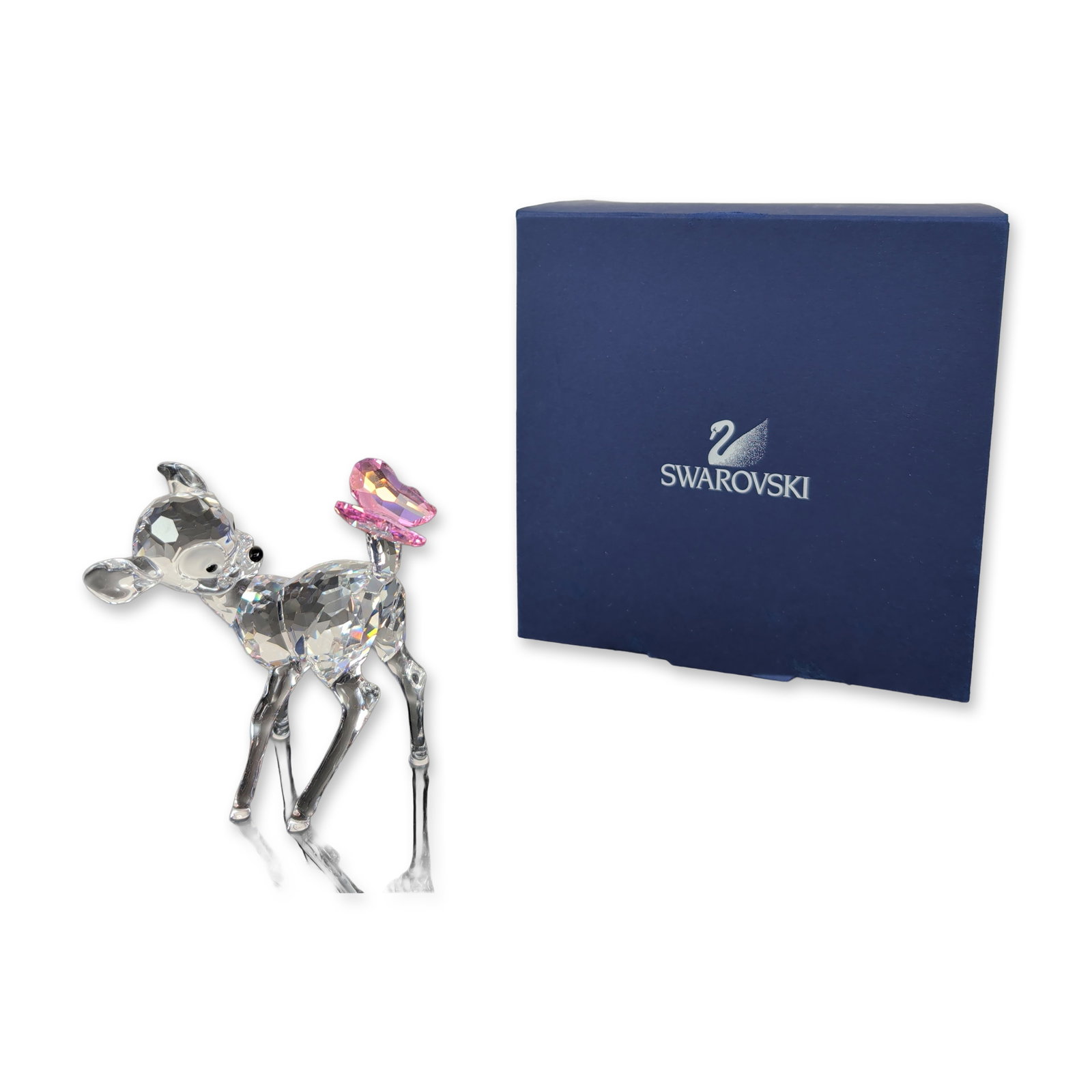 Swarovski Disney Bambi Crystal Figurine: This Swarovski Austrian lead crystal figurine from the Disney collection features a fawn crafted in faceted clear crystal, with jet crystal eyes and nose. A pink crystal butterfly with an iridescent f