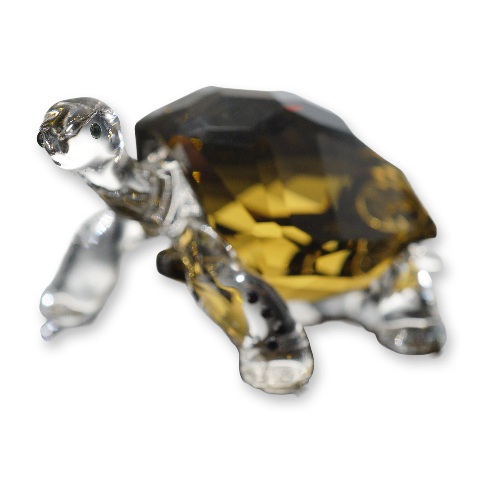Swarovski Crystal Galapagos Tortoise Figurine: Swarovski. Galapagos Tortoise figurine in clear and smoked topaz faceted crystal, produced as a 2010 SCS Event piece. The figurine features an amber-colored faceted shell and underside, with molded cl
