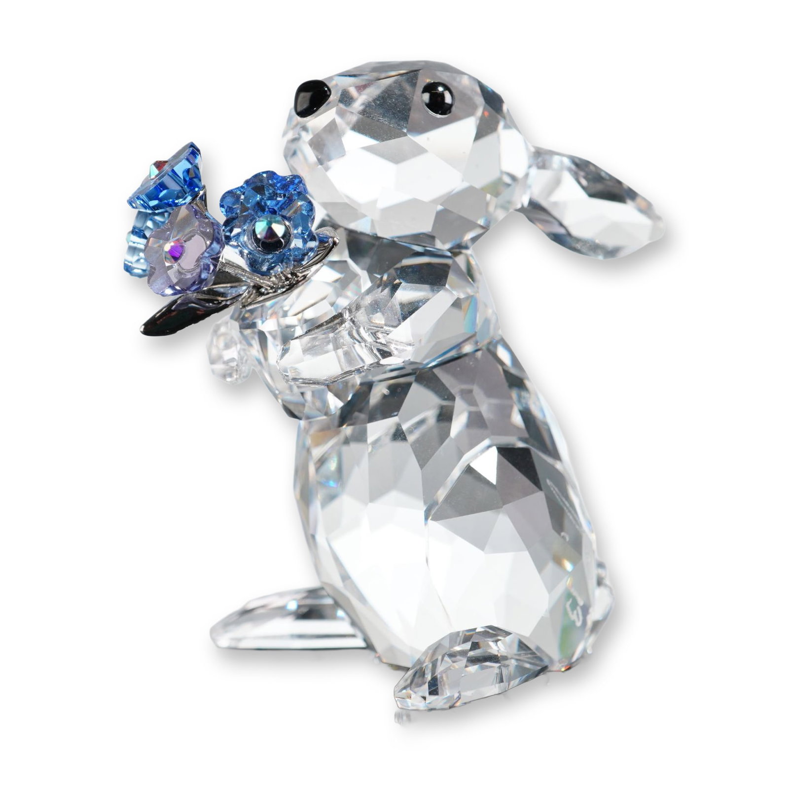 Swarovski Crystal Figurine, Rabbit with Forget-Me-Nots: Swarovski crystal figurine titled Rabbit with Forget-Me-Nots. The piece depicts a rabbit in an upright pose, crafted from faceted clear lead crystal with small, black bezel-set crystal eyes. The rabbi