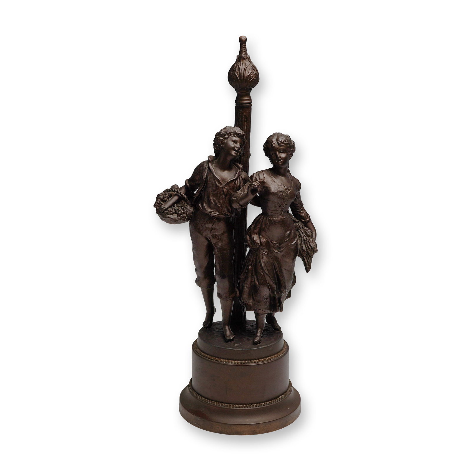 Figural Boy and Girl Lamp Sculpture with Central Post, Bronze-Finish: A decorative figural lamp sculpture comprising a young boy and girl in period dress, walking arm in arm beside a central lamppost-style shaft topped with an ornate finial. The figures are cast in a