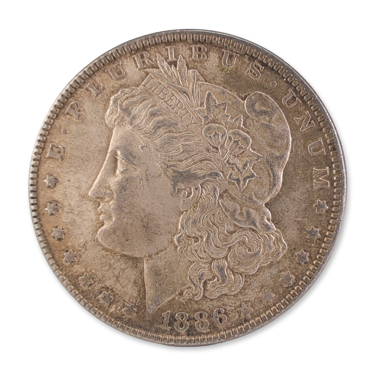 1886 US Morgan One Dollar Silver Coin, Circulated: US 1886 Morgan silver dollar, Philadelphia Mint. Struck in 90% silver and 10% copper. Obverse features the George T. Morgan design of Liberty in profile with the legend E PLURIBUS UNUM and the date