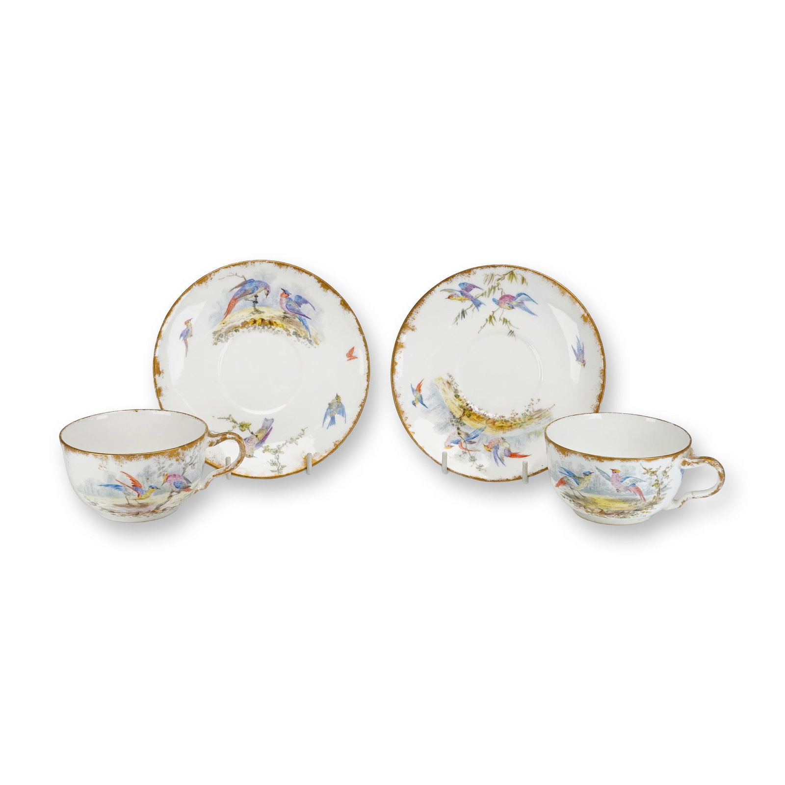 Wedgwood Porcelain Bird-Themed Teacup and Saucer Sets, 4 Pieces Total: This lot consists of 2 sets of Wedgwood porcelain teacups and matching saucers, for a total of 4 pieces. Each piece features hand-painted polychrome decoration of various exotic birds perched on branc