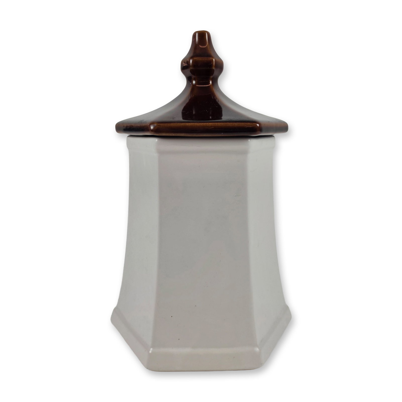 McCoy Pagoda Sunflower Ceramic Canister: Hexagonal pagoda-style kitchen canister in glazed earthenware, featuring a tapered cream-colored body and a contrasting chocolate brown hexagonal lid with a molded finial. One face is decorated with a