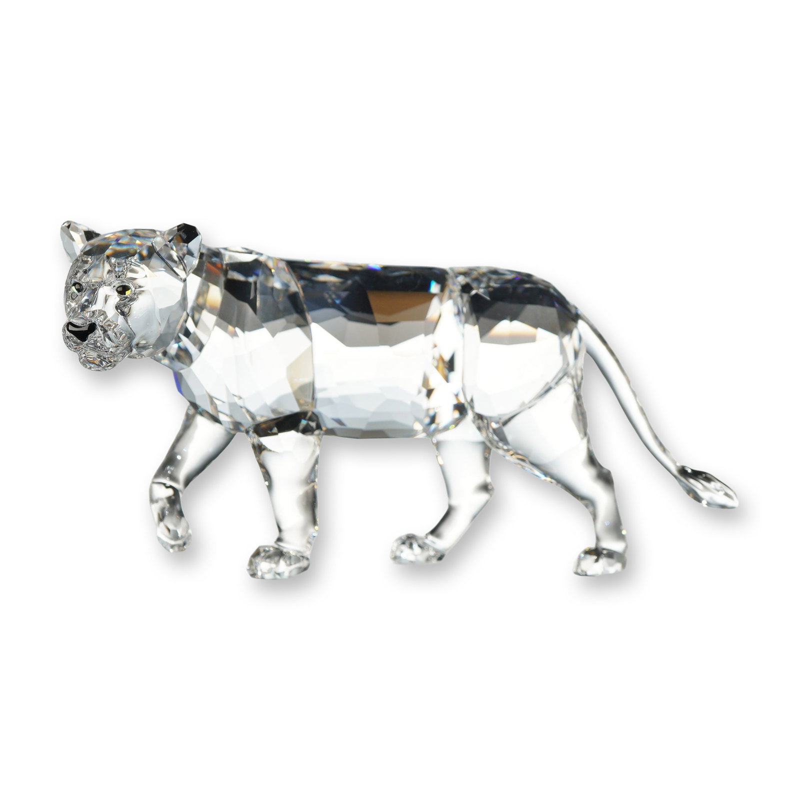 Swarovski Crystal Lion Mother Figurine: Swarovski faceted clear crystal figurine depicting a walking lioness, model number 1194085. The feline is rendered in a stalking pose with its front-left paw raised. The flat underside of one paw feat