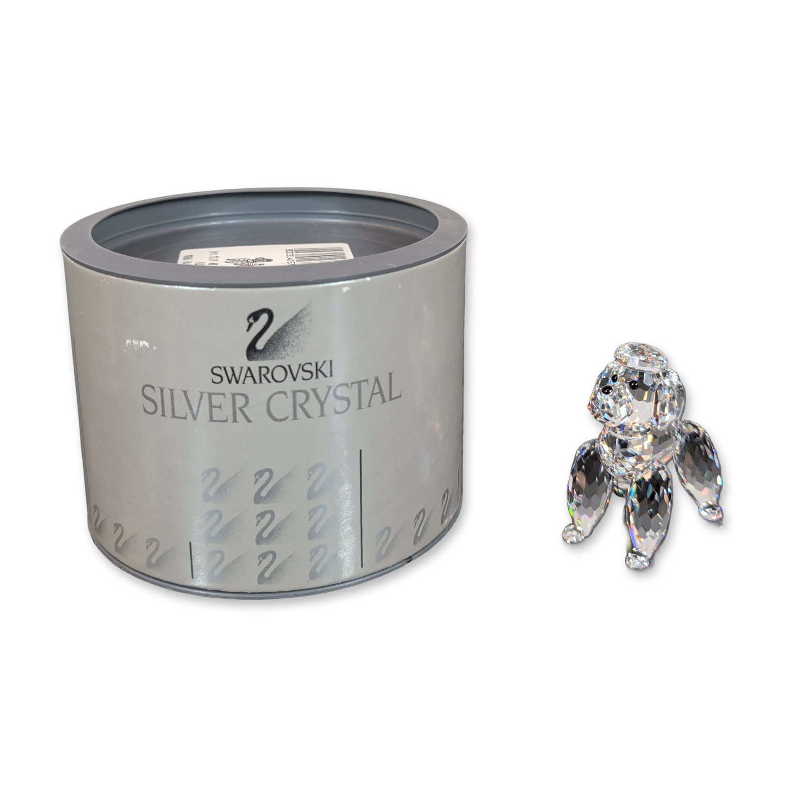 Swarovski Crystal Poodle Figurine: Swarovski Silver Crystal figurine in clear faceted lead crystal. The piece depicts a poodle in a standing posture with a faceted body and head, featuring smooth and faceted pom-pom accents on the paws
