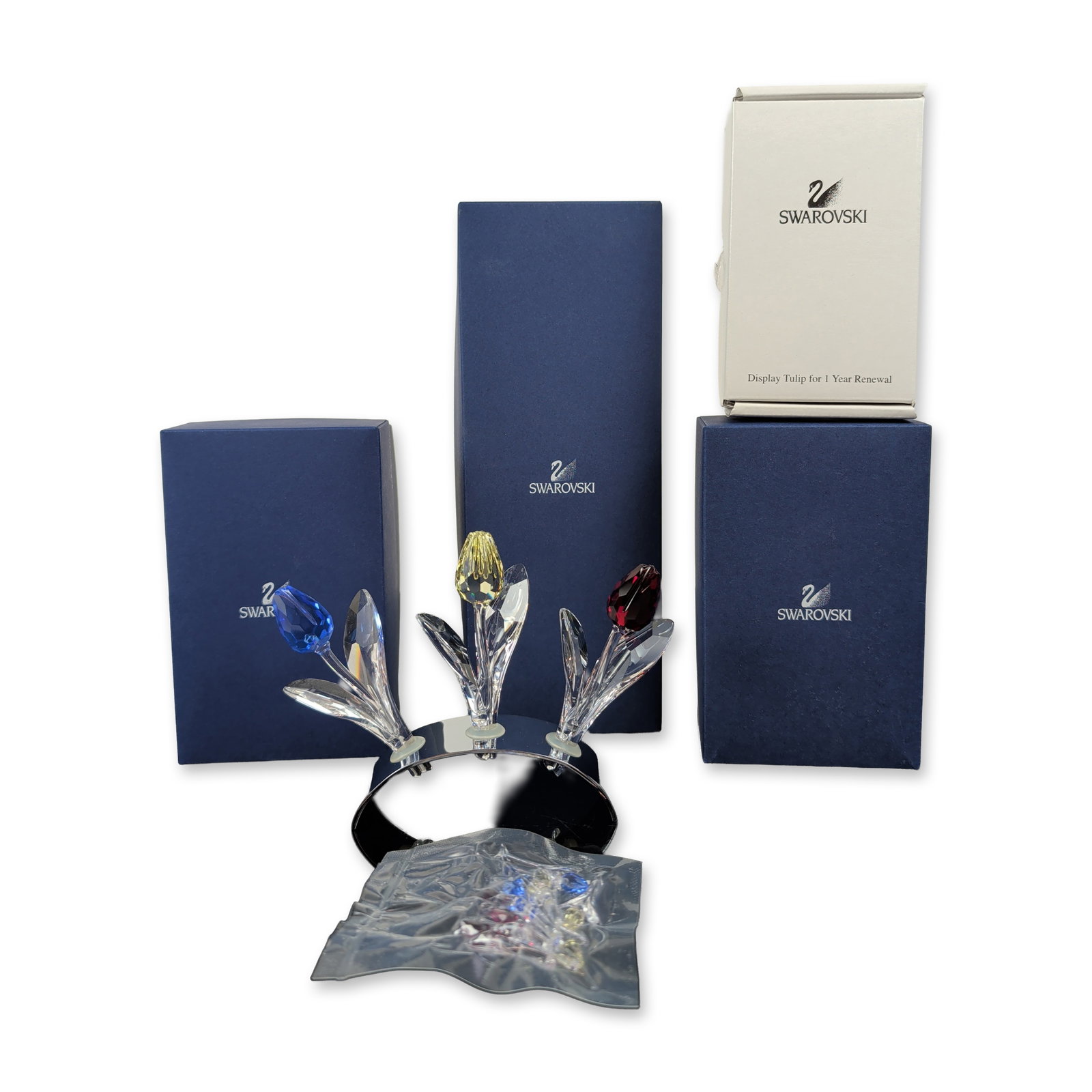 3pc Swarovski SCS Crystal Tulip Figurines with Base Collection: Swarovski trio of faceted lead crystal tulips from the Swarovski Crystal Society (SCS) collection, featuring individual flowers in red, yellow, and blue. Each figurine is composed of a colored faceted