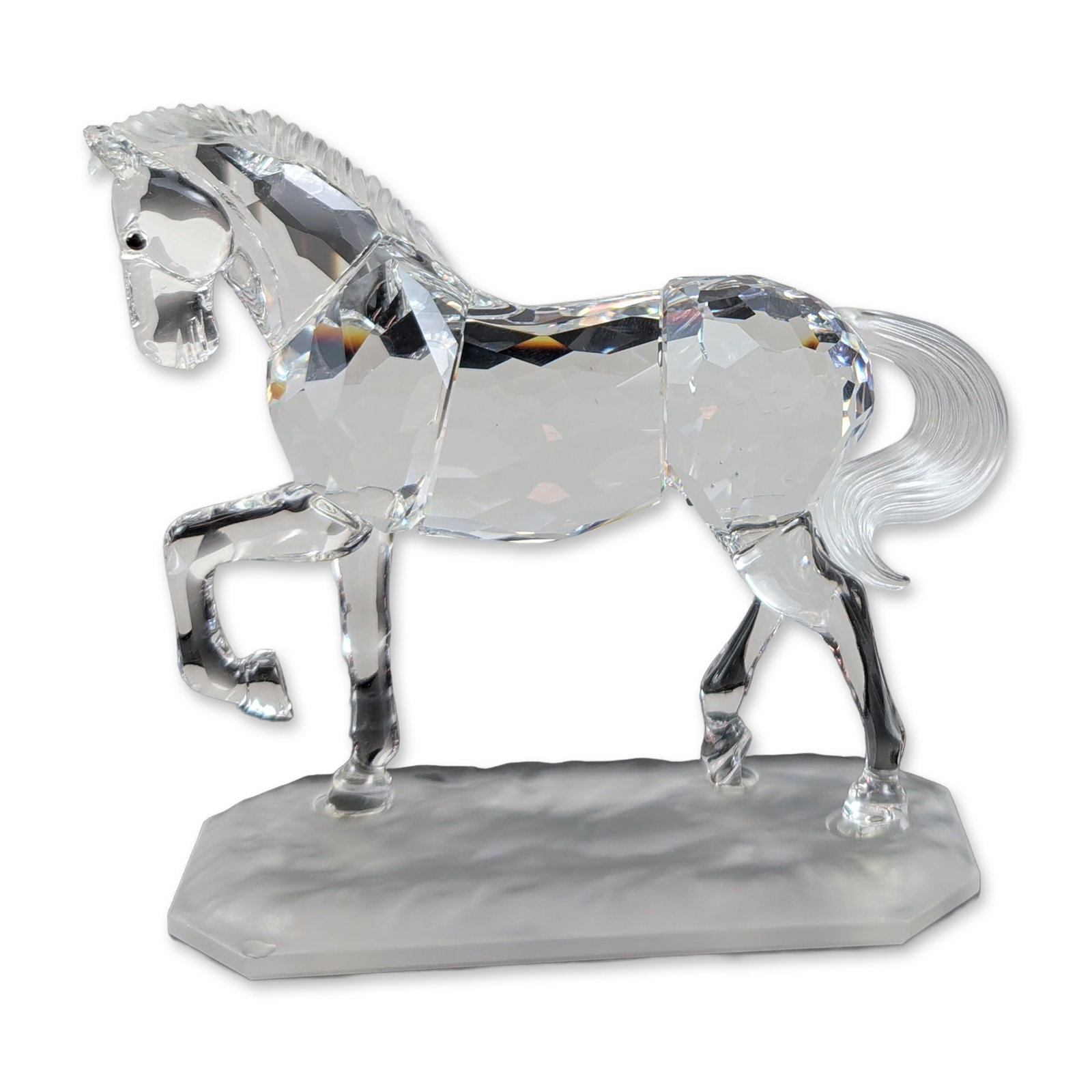 Swarovski Crystal Arabian Stallion Horse Figurine: A dazzling Swarovski faceted clear crystal figurine of an Arabian stallion, captured in a dynamic pose with its front left leg gracefully raised. The horse showcases a beautifully frosted mane and a f