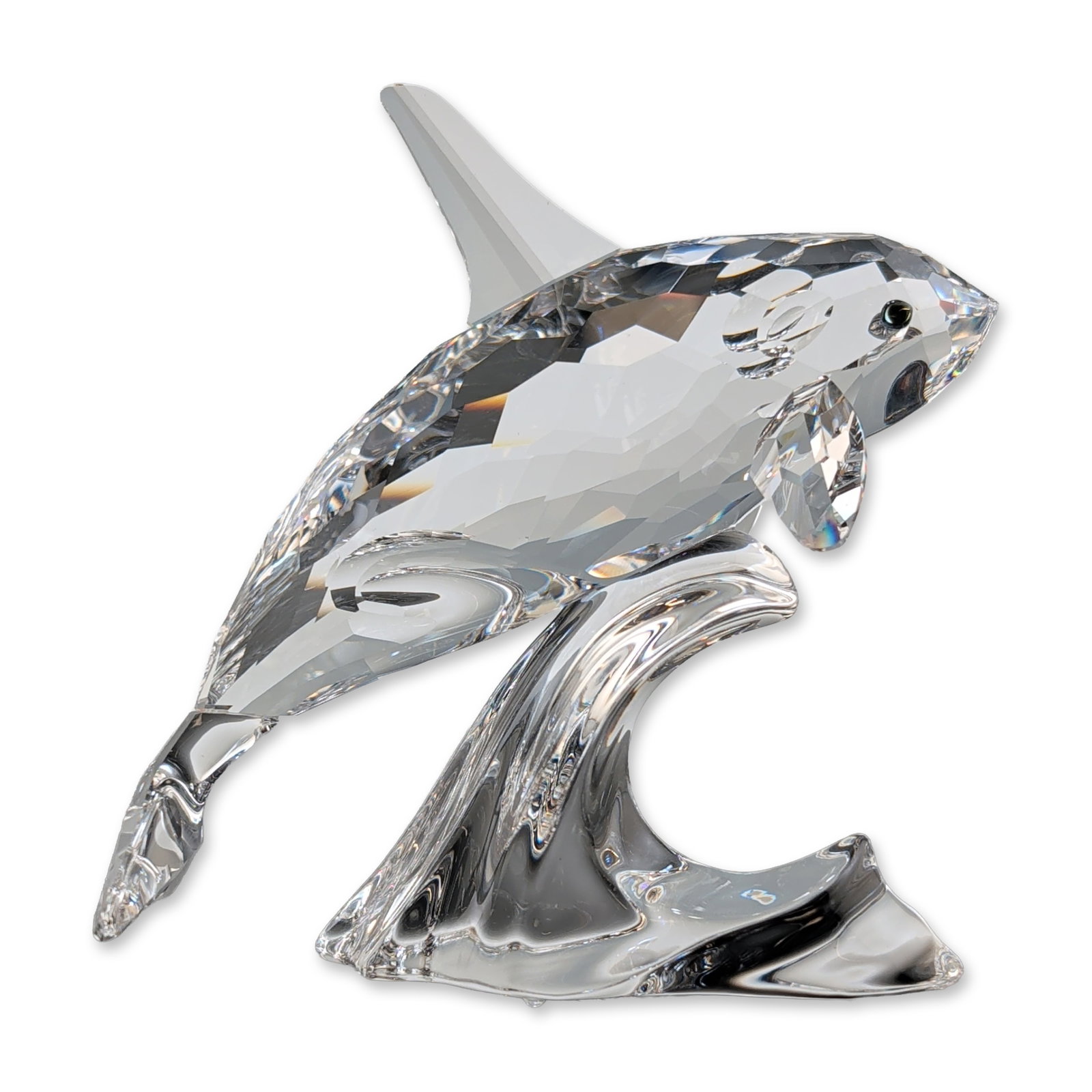 Swarovski Crystal Orca Whale Figurine: Swarovski faceted lead crystal figurine depicting an orca whale leaping above a molded crystal wave base. Features an acid-etched swan maker mark to the base. Accompanied by the original blue presenta