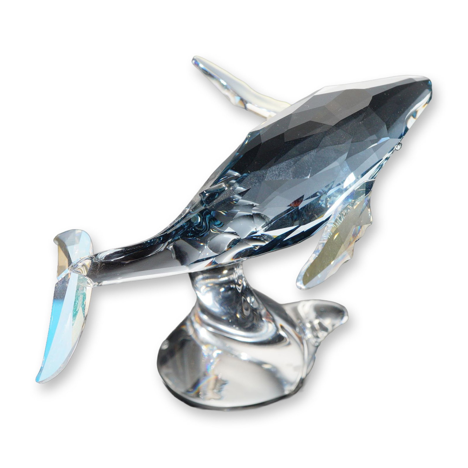 Swarovski SCS 2012 Annual Edition Paikea Young Whale: Swarovski Crystal Society (SCS) 2012 Annual Edition. Young whale figurine titled Paikea in faceted and molded crystal, featuring a dark blue-grey faceted body with clear crystal fins and tail, mounted