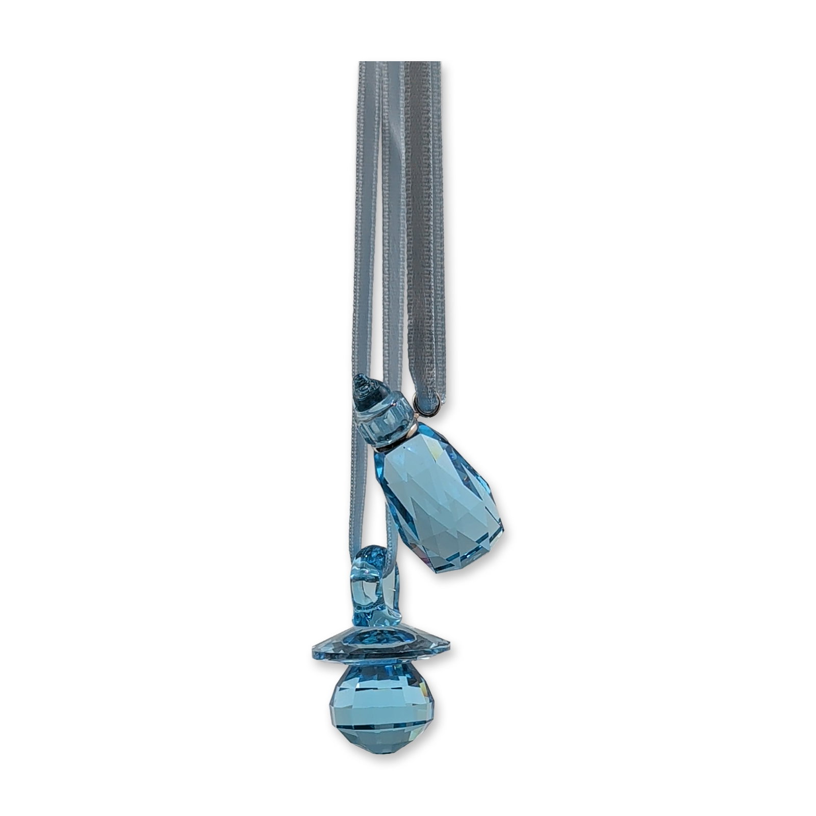 Swarovski Crystal Baby Boy Pacifier and Bottle Ornaments: Pair of baby-themed ornaments in faceted light blue crystal, including a miniature baby bottle and a pacifier. Each piece is suspended from a light blue satin ribbon. Includes original branded Swarovs