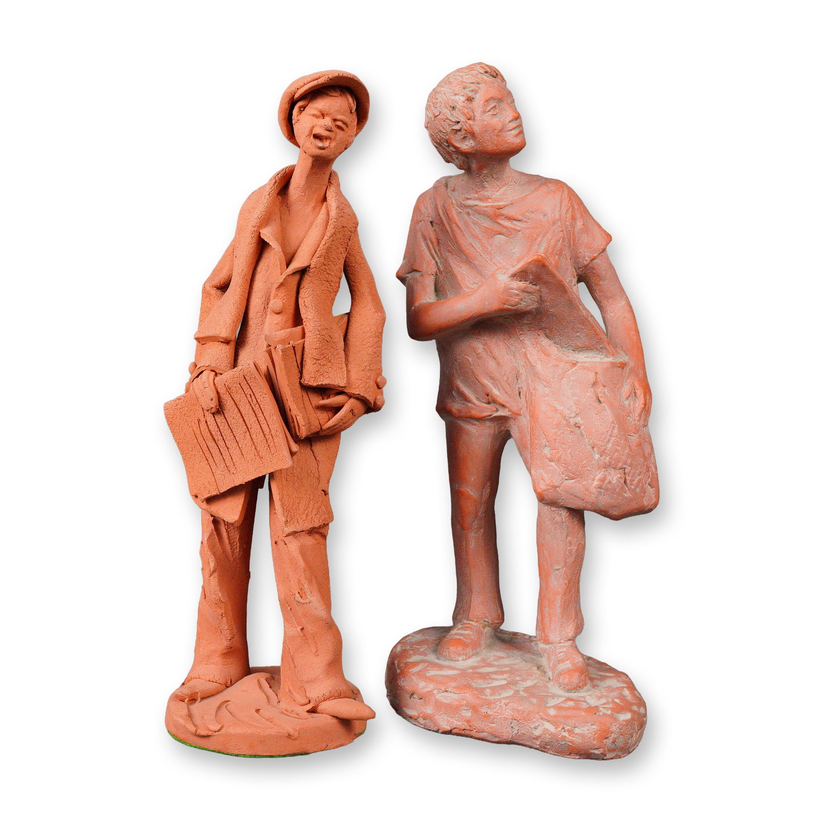 Group of Two Terracotta Newspaper Men Figurines: A group of two hand formed terracotta sculptures depicting elongated standing figures. One shows a person wearing a cap and long coat, holding newspapers and a book. The other presents a youth in a sh