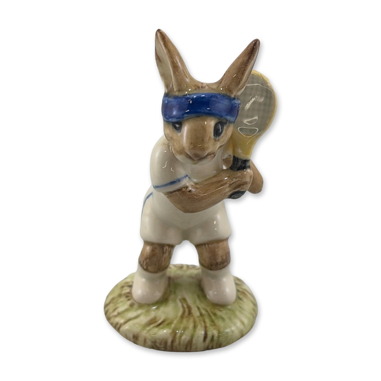 Royal Doulton Ace Bunnykins Ceramic Figurine DB 42: Royal Doulton. Glazed ceramic figurine titled Ace Bunnykins, model DB 42. Depicts a rabbit dressed in a white tennis outfit with blue trim and a blue headband, holding a tennis racket. Marked on the u