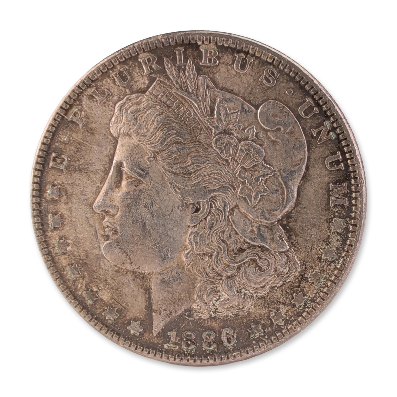 1886 US Morgan One Dollar Silver Coin, Circulated: US 1886 Morgan silver dollar, struck at the Philadelphia Mint. Composed of 90 percent silver, featuring the standard Liberty head obverse and heraldic eagle reverse. Reeded edge. Diameter: 38.1 mm; We